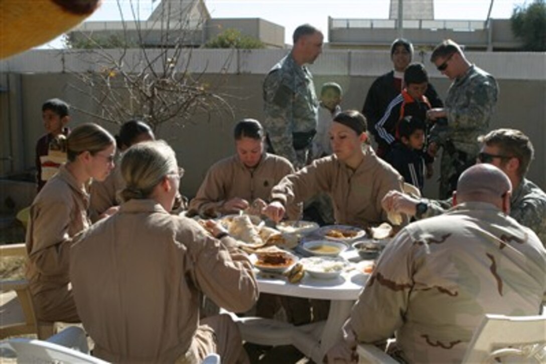 U.S. Marines and Navy sailors from Marine Wing Support Squadron eat lunch with residents of Baghdad, during an Iraqi women's engagement, Jan. 24, 2007. 