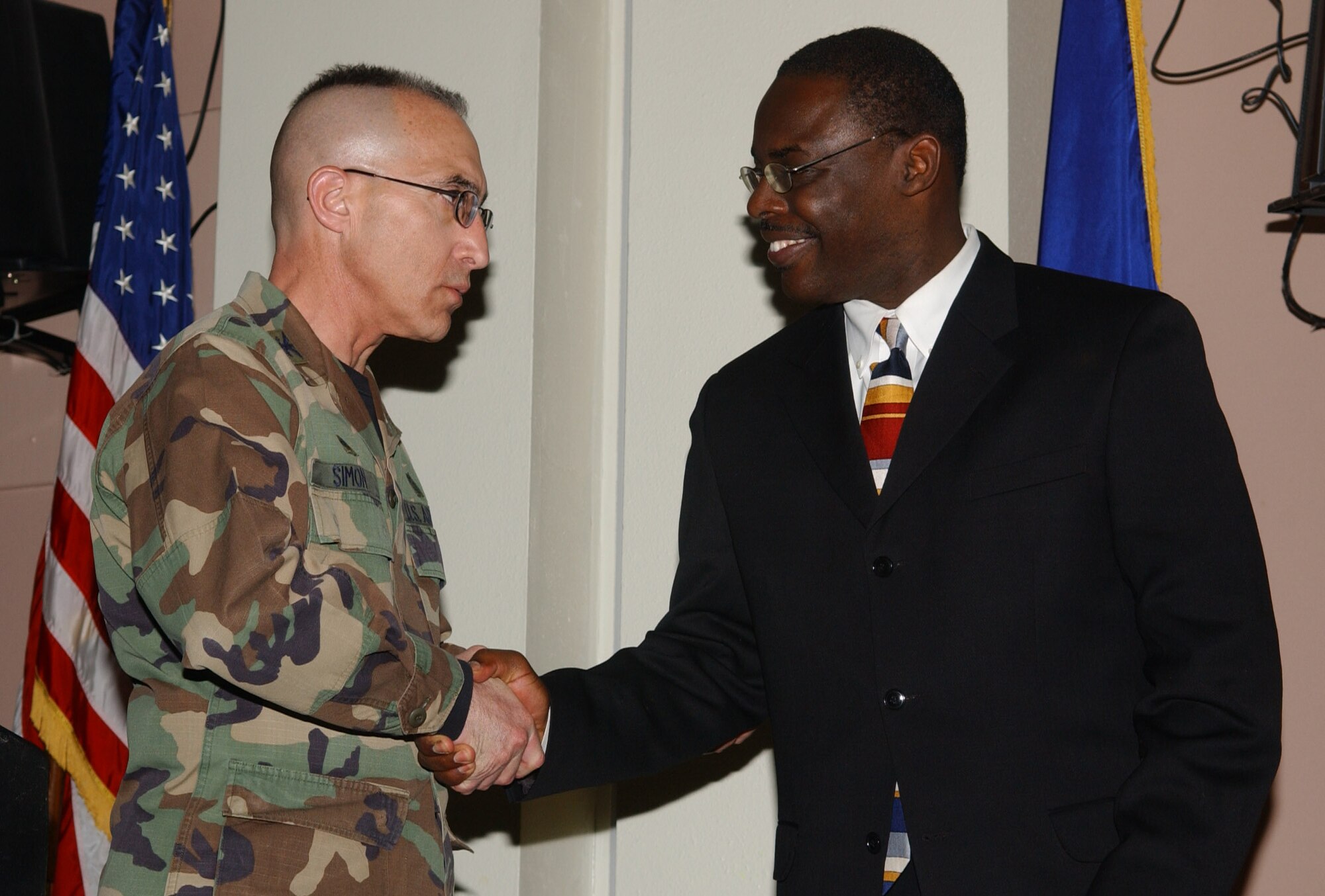 Air Force Col. Barry Simon, 17th Medical Group commander shakes hands with Dr. Joe Coleman, Central High School principal.  Col. Simon was the observance's sponsor while Dr. Coleman was the event's guest speaker.   (U.S. Air Force photo by Airman 1st Class Kamaile Chan)