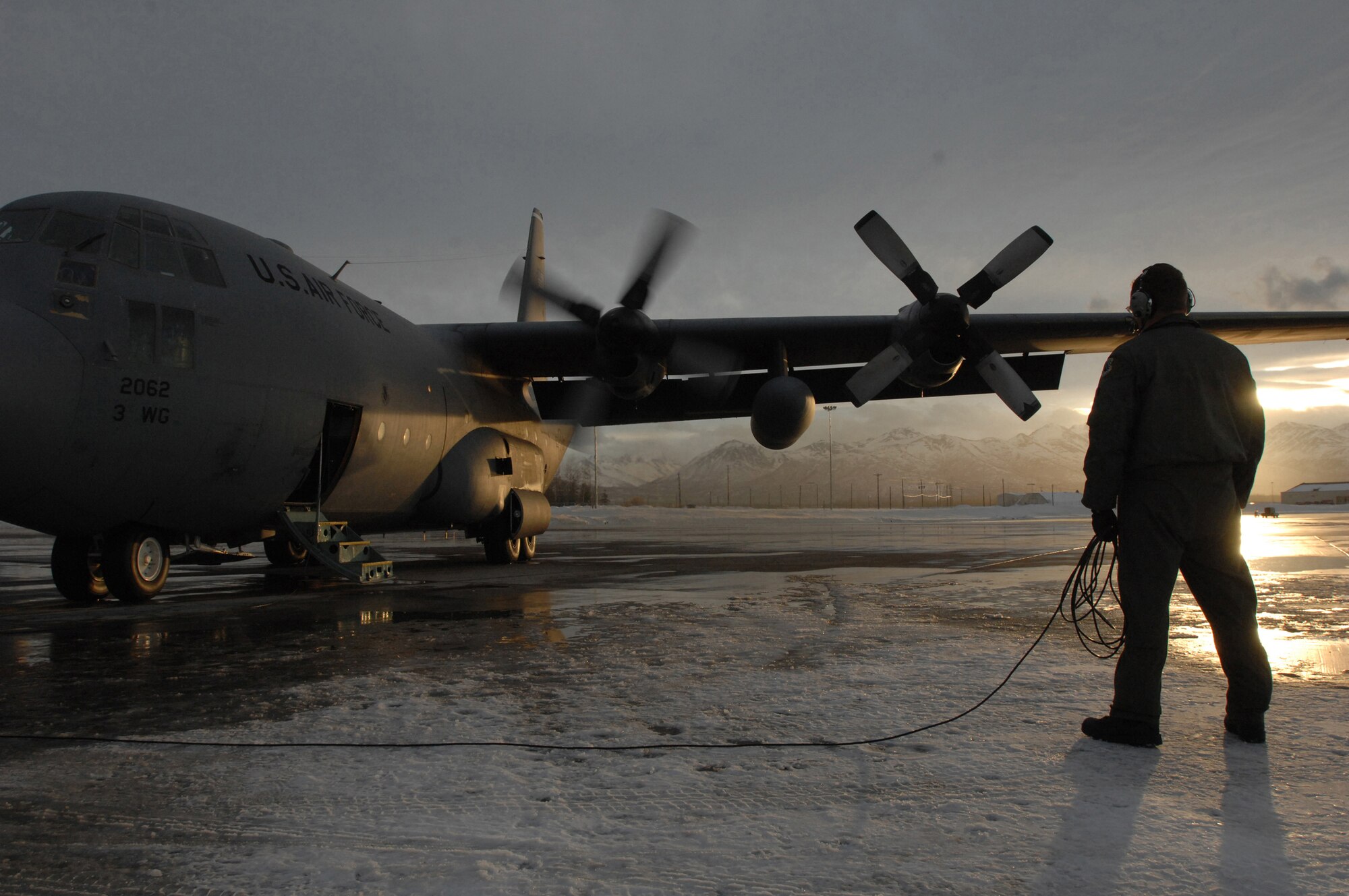 ELMENDORF AIR FORCE BASE, Alaska -- An Elmendorf Airman directs engine start up on a C-130 prior to an training mission to the Alaskan Interior. The C-130 belongs to the 517th Airlift Squadron. The 517th AS will replace its fleet of C-130s with the C-17 Globemaster III later this year. (Photo by Tech. Sgt. Keith Brown)