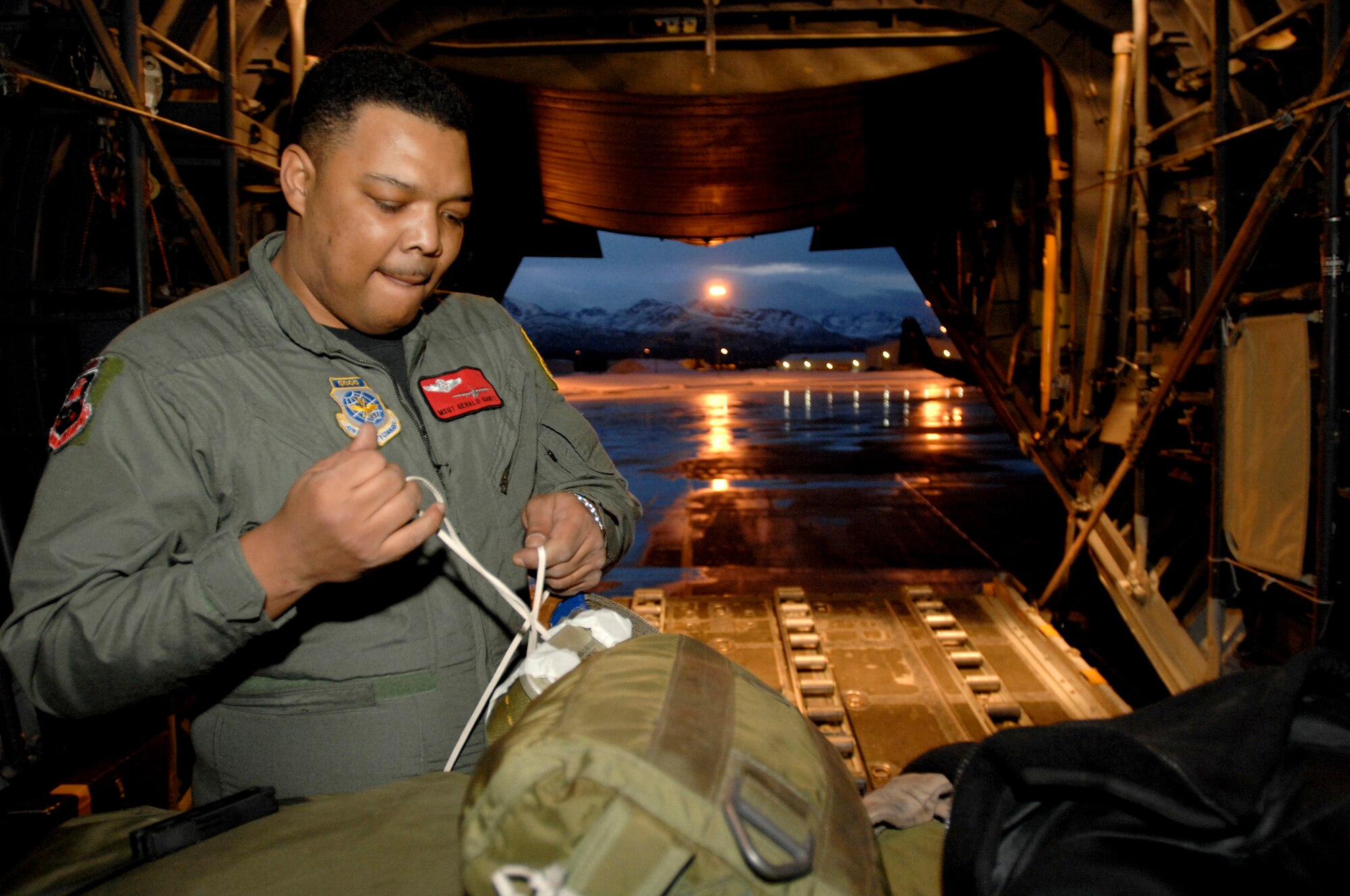 ELMENDORF AIR FORCE BASE, Alaska -- Master Sgt. Gerald Gantt attaches parachutes to a pallet in preparation for a training mission to the Alaskan Interior. Sergeant Gantt is a load master with the 517th Airlift Squadron. The 517th AS will replace its fleet of C-130s with the C-17 Globemaster III later this year. (Photo by Tech. Sgt. Keith Brown)