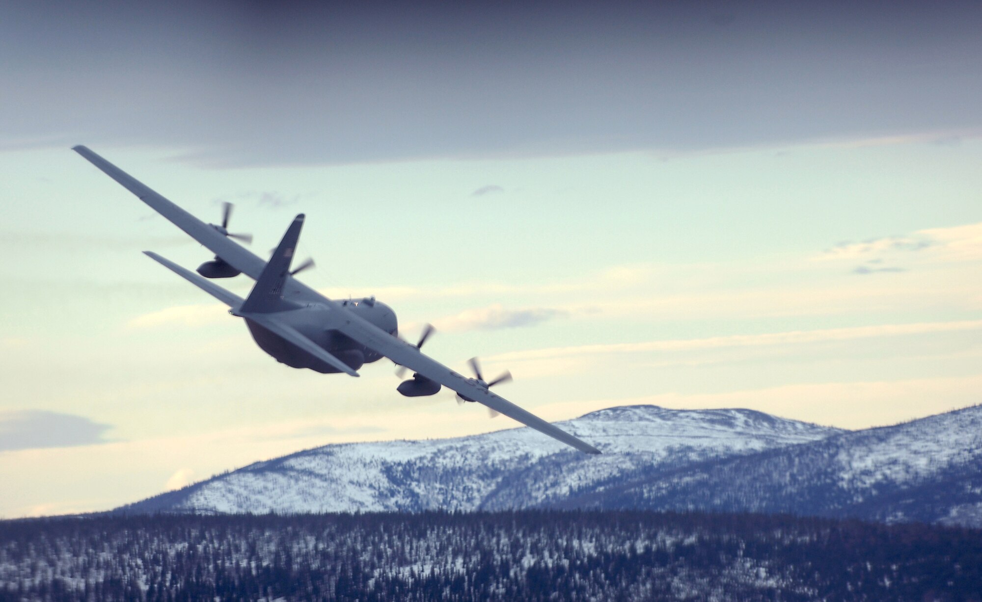 ELMENDORF AIR FORCE BASE, Alaska -- A C-130 flys a training mission which dropped pallets of simulated supplies at designated points along the Alaskan Interior. The C-130 belongs to the 517th Airlift Squadron. The 517th Airlift Squadron will replace its fleet of C-130s with the C-17 Globemaster III later this year. (Photo by Tech. Sgt. Keith Brown)