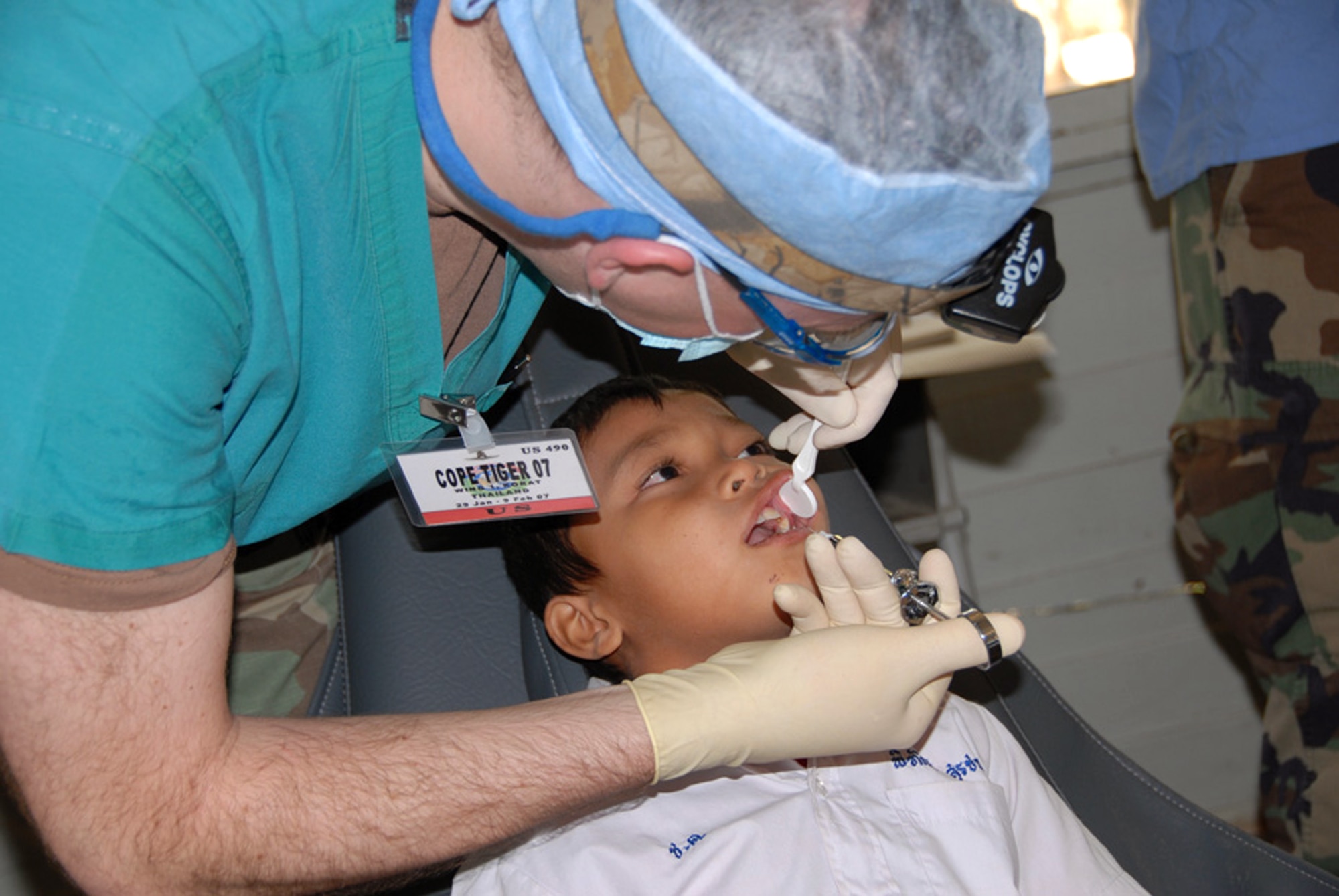 Capt. Alan Neal performs a tooth extraction on a student from the Ban Chaimongkon school Jan. 30 in Korat, Thailand. Military members from the United States, Thailand and Republic of Singapore took part in a humanitarian mission at the school as part of Exercise Cope Tiger 2007. Captain Neal is a dentist from the 35th Dental Squadron at Misawa Air Base, Japan. (U.S. Air Force photo/Staff Sgt. Betty Squatrito-Martin) 

