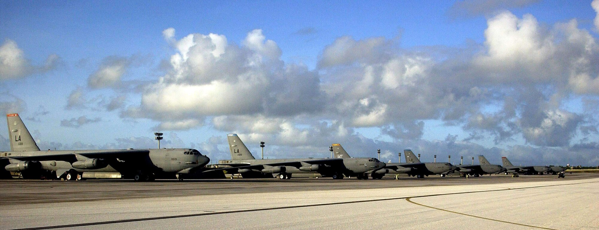 A row of B-52 Stratofortresses from Barksdale Air Force Base, La., and Minot AFB, N.D., await their next mission on the flightline Feb. 1 at Andersen AFB, Guam. The different colored tail markings represent the individual squadrons each bomber is assigned to at their home station. Approximately 300 Airmen from Barksdale AFB arrived on Guam recently as part of a scheduled rotation of bomber units into the Pacific theater. (U.S. Air Force photo/Senior Master Sgt. Don Perrien) 
