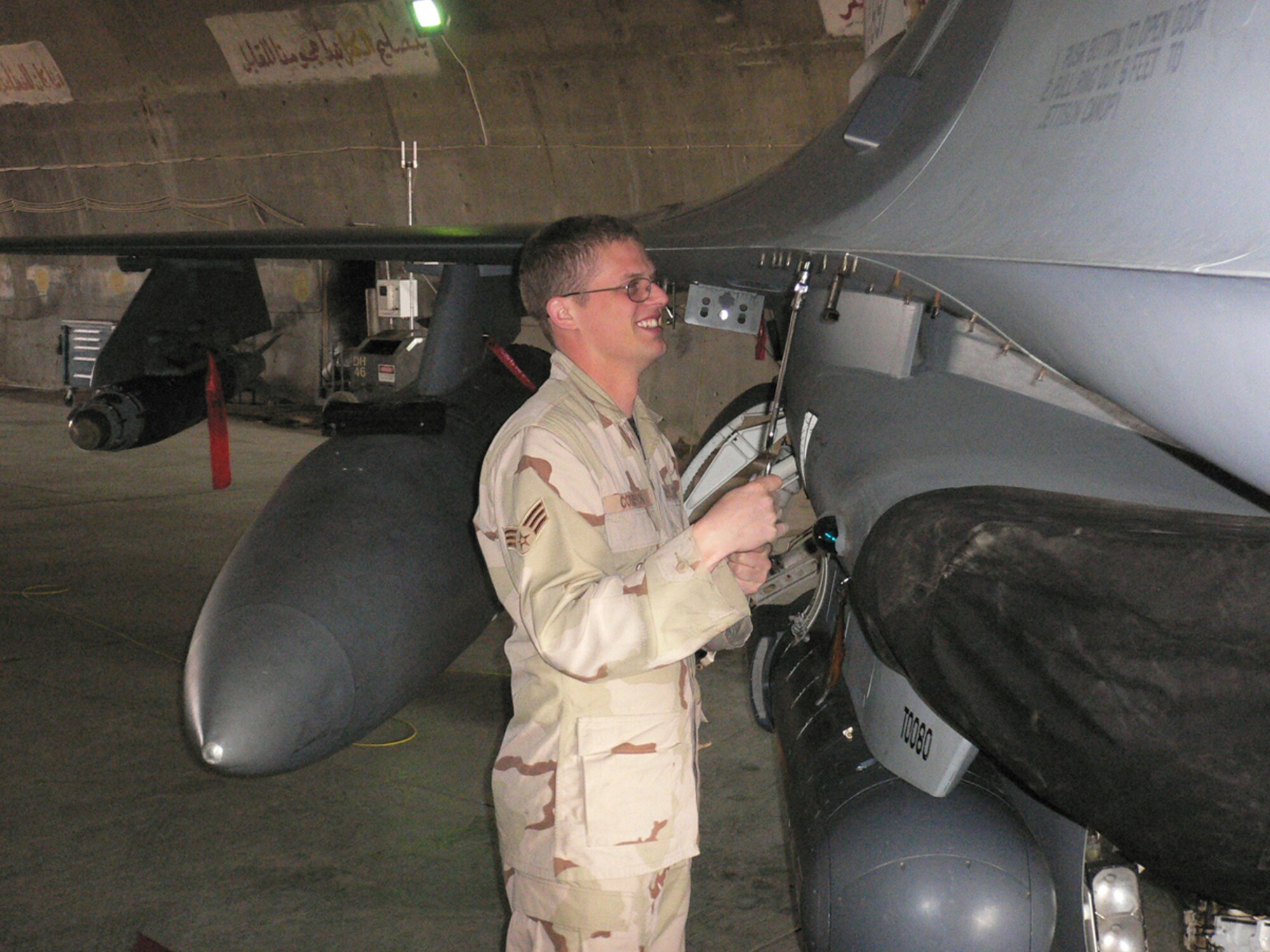 02/02/2007 -- BALAD AIR BASE, Iraq -- Staff Sgt. Robert Compton, 332nd Expeditionary Aircraft Maintenance Squadron, performs preventive maintenance on a F-16 jet here. Sergeant Compton who was recently promoted is deployed from the 35th Aircraft Maintenance Squadron at Misawa Air Base, Japan. (U.S. Air Force photo by Capt. Jeffrey Campbell)