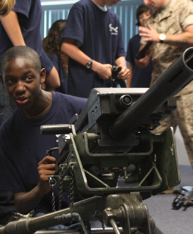 Diante Aikens, a 14-year-old Morongo Unified School District student, simulates firing an MK-19 automatic grenade launcher during the Career Pathways event May 29 at Paige Hall.