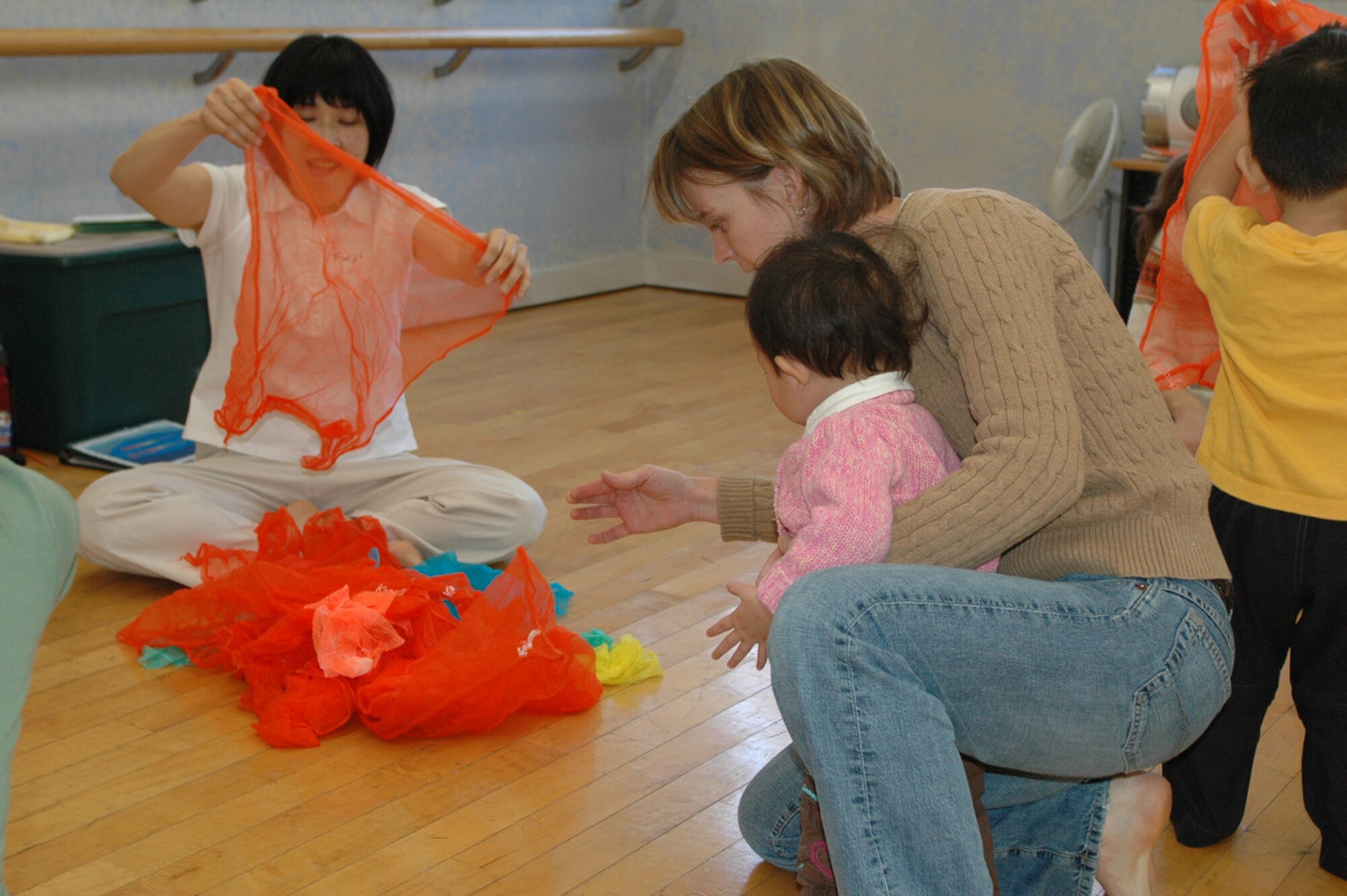 YOKOTA AIR BASE, Japan -- Mie Fujimori, left, shows Ms. Diane Burch, and her daughter Maggie, how to have fun with scarves and music. (U.S. Air Force by Jennifer Hensley)