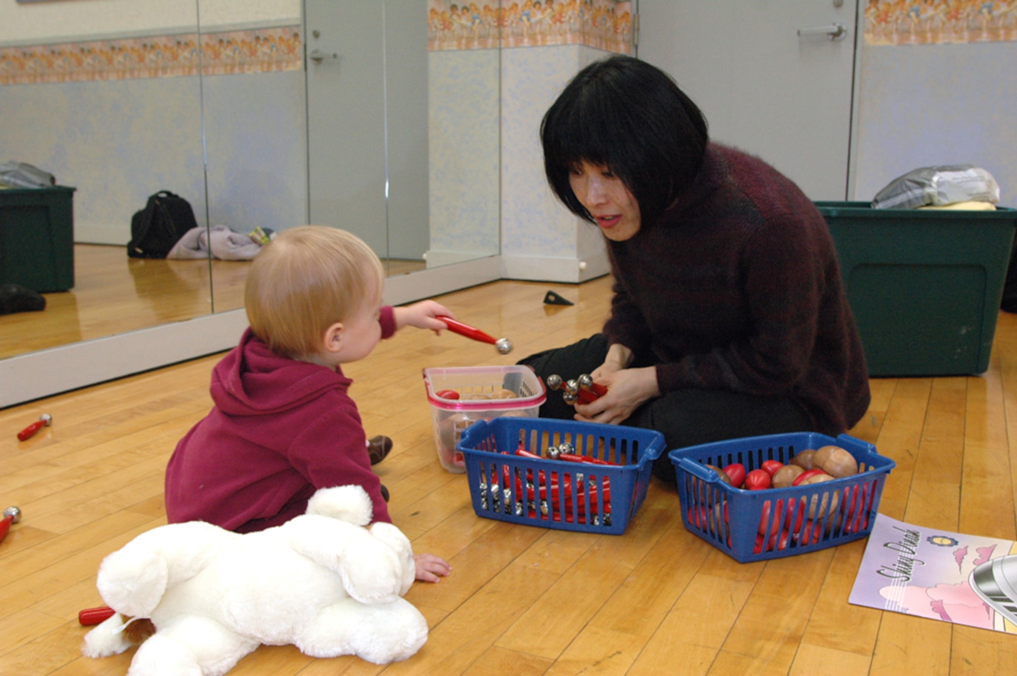 YOKOTA AIR BASE, Japan -- Lily Hensley, left, receives instruments to experience different tones in the Kindermusik class. (U.S. Air Force photo by Jennifer Hensley)