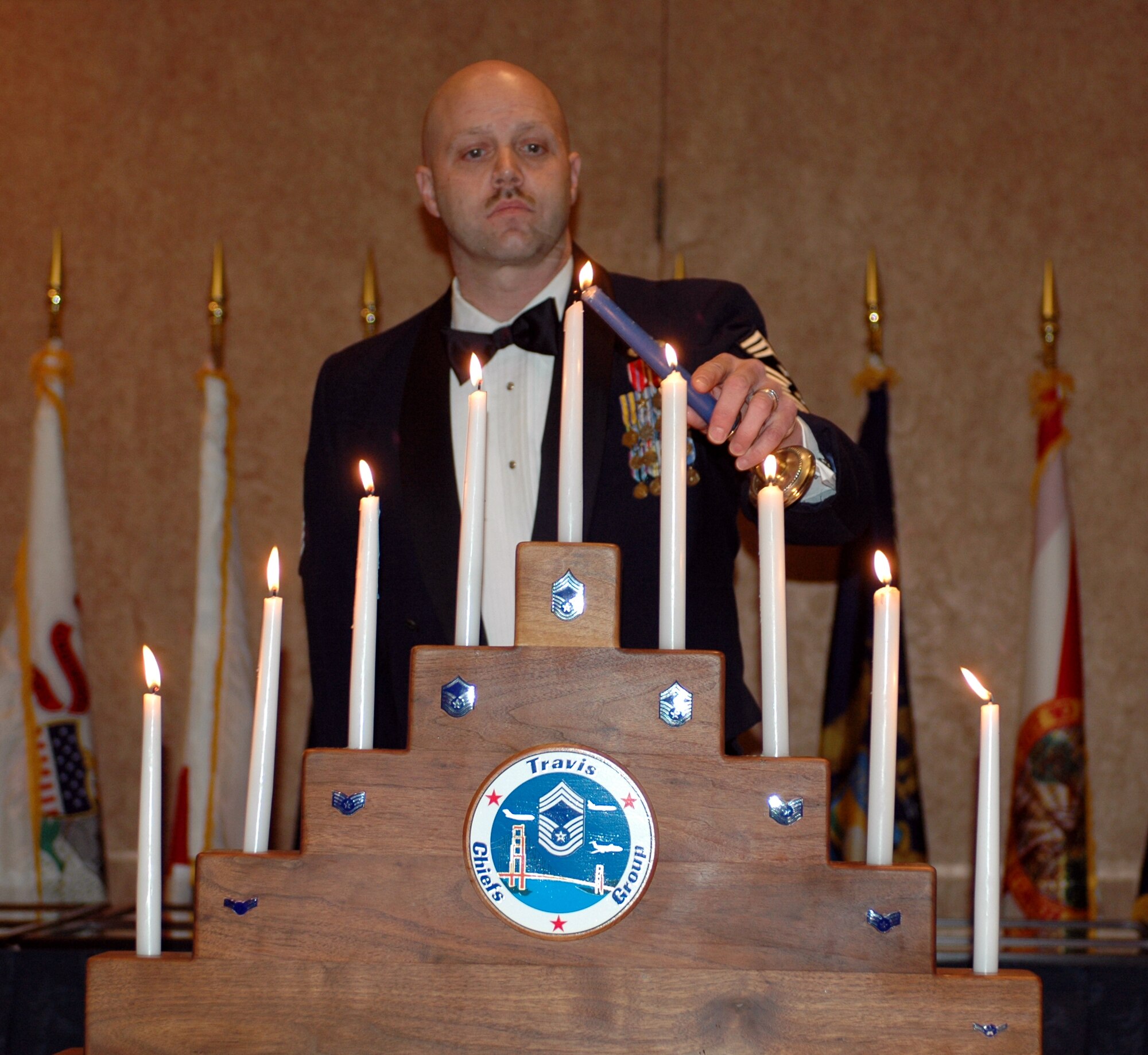 Chief Master Sgt. Thomas Schwiesow, 615th Contingency Response Wing command chief, lights the chief master sergeant candle during the Chief’s Induction ceremony Feb. 2. During the ceremony, a candle was lit for each enlisted rank, signifying the journey from airman basic to chief master sergeant. Team Travis honored 14 of their newest chief master sergeants during a formal recognition ceremony at the Delta Breeze Club. (U.S. Air Force photo by Staff Sgt. Candy Knight)