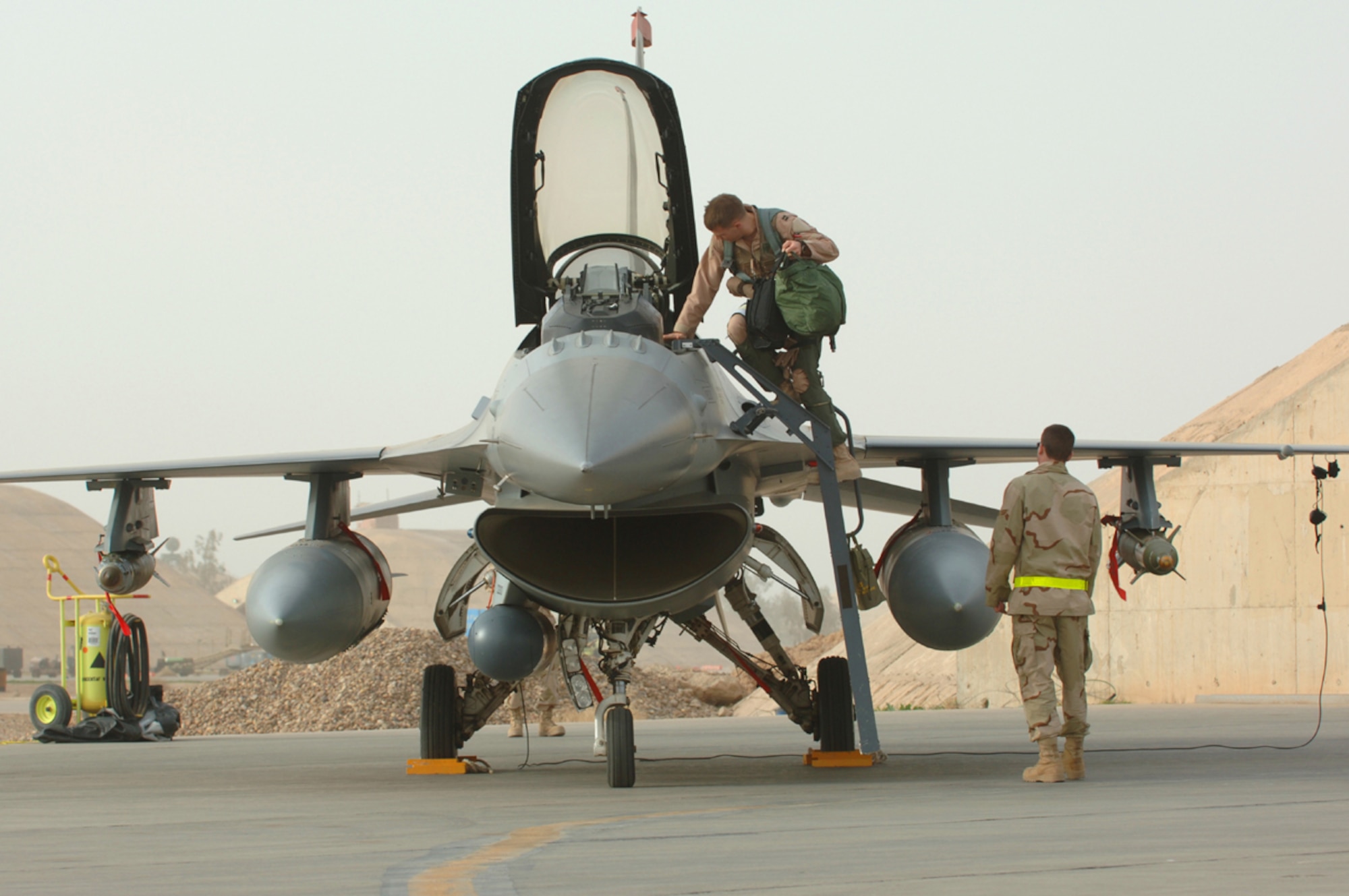01/29/2007 -- BALAD AIR BASE, Iraq -- Capt. William "Shogun" Lutmer, deployed to the 332nd Air Expeditionary Wing here as part of the 14th Expeditionary Fighter Squadron climbs into his Block 50 F-16 while his Crew Chief Senior Airman Skylar Mims, 14th Expeditionary Aircraft Maintenance Squadron, prepares to assist him before departing on a combat mission over Iraq Jan. 29.  The 14th Fighter Squadron is deployed from Misawa Air Base, Japan, and is the first Block 50 F-16 squadron deployed to Iraq (U. S. Air Force photo by Staff Sgt. Michael R. Holzworth) 

