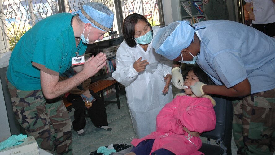 Capt. Allan Neal a Dentist with the 35th Dental Squadron, Misawa Air Base, Japan thanks a patient for her cooperation while Senior Airman Marshawn Walker packs the girl's mouth with cotten gauze following a tooth extraction Feb. 6. The two Air Force dental personnel were in Northern Thailand as part of a medical dental goodwill mission to the Thairat 72 school in Udon Thani. This medical dental mission was the second mission in Thailand as part of Exercise Cope Tiger 2007. (USAF photo by Staff Sgt. Betty Squatrito-Martin)