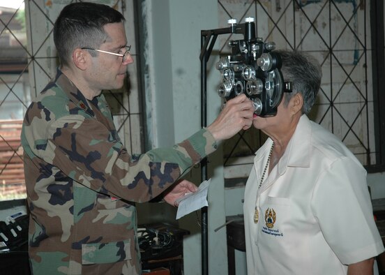 Maj. Carlos Cebollero an optometrist with the 374th Medical Group Yokota Air Base, Japan conducts a refraction test with a phoropter on a patient during a medical dental goodwill mission at the Thairat 72 School in Northern Thailad Feb. 6. The test helps judge the proper prescription for eyeglasses. Major Cebollero is in Thailand as part of Exercise Cope Tiger 07. (USAF photo by Staff Sgt. Betty Squatrito-Martin)
