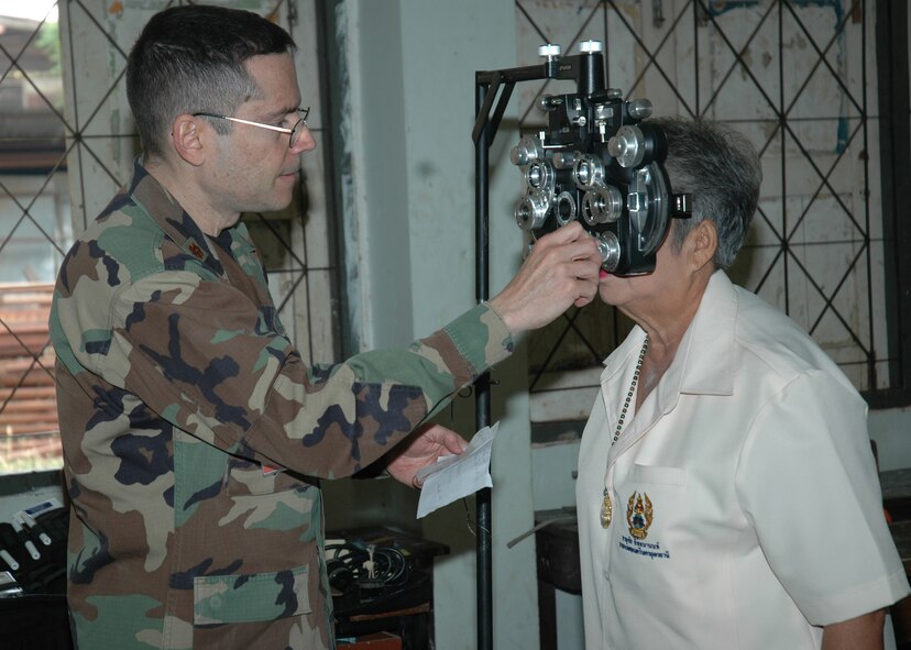 Maj. Carlos Cebollero an optometrist with the 374th Medical Group Yokota Air Base, Japan conducts a refraction test with a phoropter on a patient during a medical dental goodwill mission at the Thairat 72 School in Northern Thailad Feb. 6. The test helps judge the proper prescription for eyeglasses. Major Cebollero is in Thailand as part of Exercise Cope Tiger 07. (USAF photo by Staff Sgt. Betty Squatrito-Martin)
