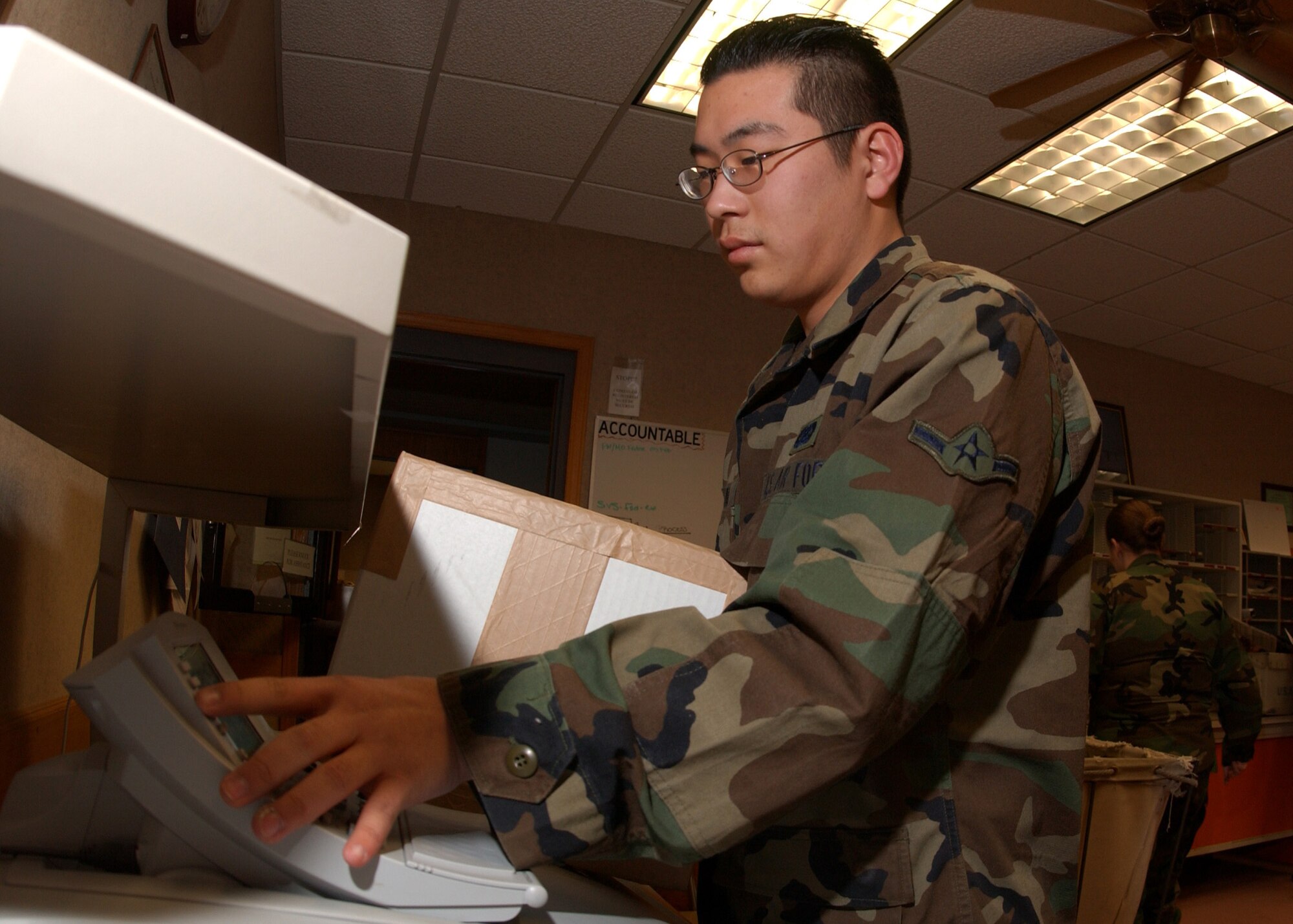 EIELSON AIR FORCE BASE, Alaska -- Airman Ken Chung, 354th Communications Squadron, uses a Postage Meter Machine to apply postage to envelopes and boxes to be shipped off on Feb. 06. The base Mail Room on a daily basis will pick up, deliver and process over 500 pieces of mail. The mail is then "pitched", sorted, and proper postage is applied to all official mail.  (U.S. Air Force photo by Airman Jonathan Snyder)