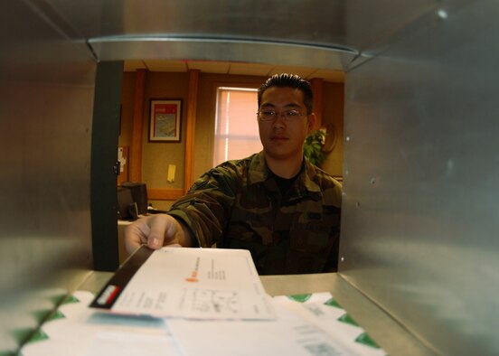 EIELSON AIR FORCE BASE, Alaska -- Airman Ken Chung, 354th Communications Squadron, pitches an envelope into a squadron mail box on Feb. 06. The base Mail Room on a daily basis will pick up, deliver and process over 500 pieces of mail. The mail is then "pitched", sorted, and proper postage is applied to all official mail.  (U.S. Air Force photo by Airman Jonathan Snyder)