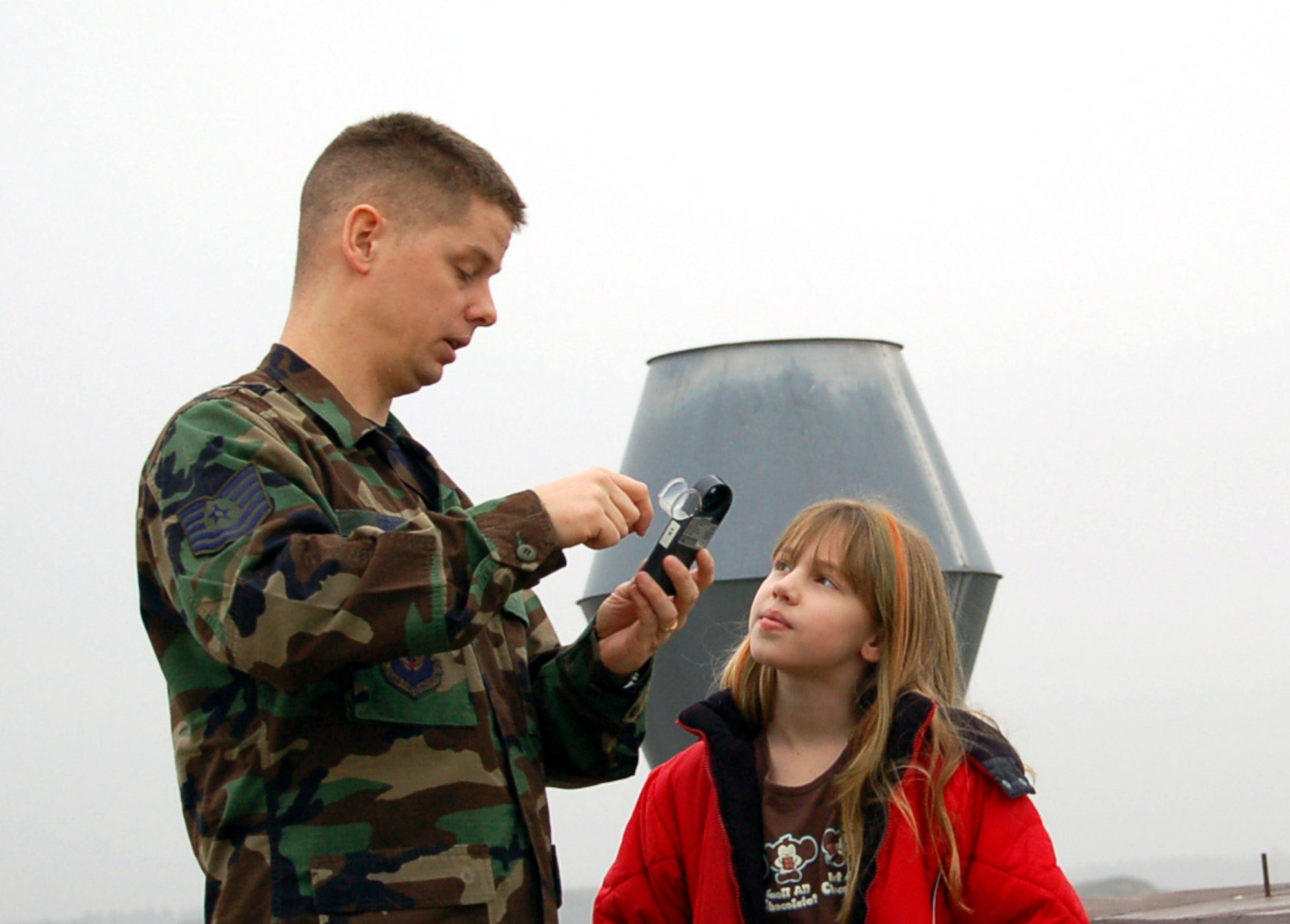 Tech. Sgt. Donald Odom explains to his daughter Mackenzie how take wind speed, temperature and dew point readings using a kestrel.  Mackenzie spent National Job Shadow Day Feb. 2 with her father learning about his job.  Sergeant Odom is a weather forecaster with the 52nd Operations Support Squadron at Spangdahlem Air Base, Germany.  (U.S. Air Force photo)