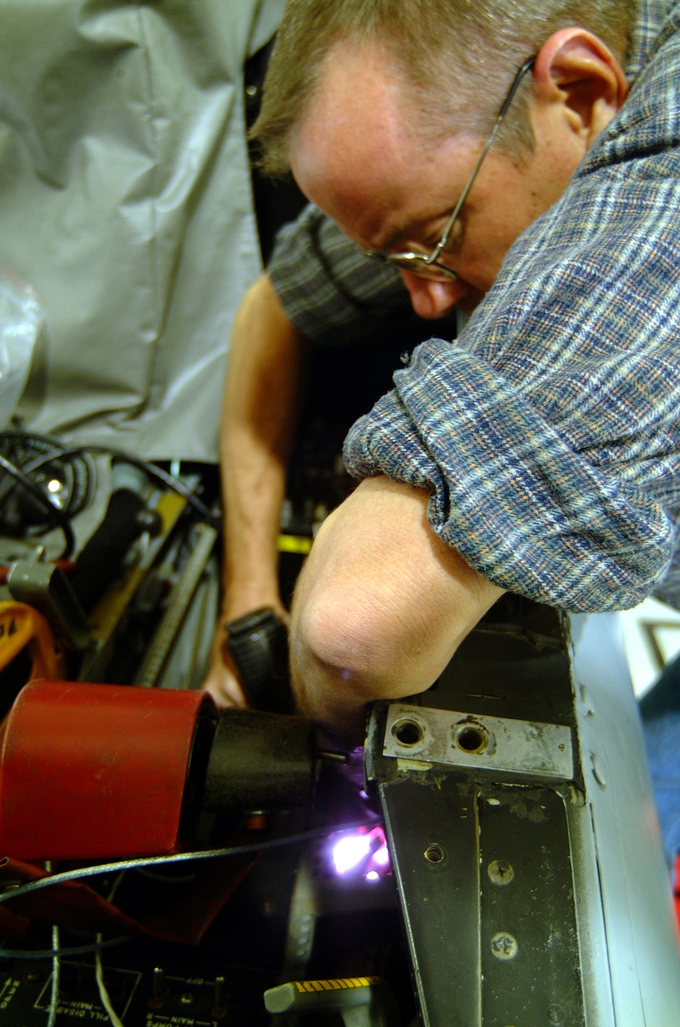 Tech. Sgt. Paul Hanson, an Air Reserve Technician avionics specialist, uses an infrared "ray gun" to heat-shrink wire connectors during the installation of a "smart" multi-function color display system in A-10 number 605.  Sergeant Hansen and the rest of the 442nd Aircraft Maintenance Squadron's Specialist Flight move the five systems in the from aircraft going into depot or phase maintenances so the wing's pilots can keep flying with the new system.  (U.S. Air Force photo/Maj. David Kurle)