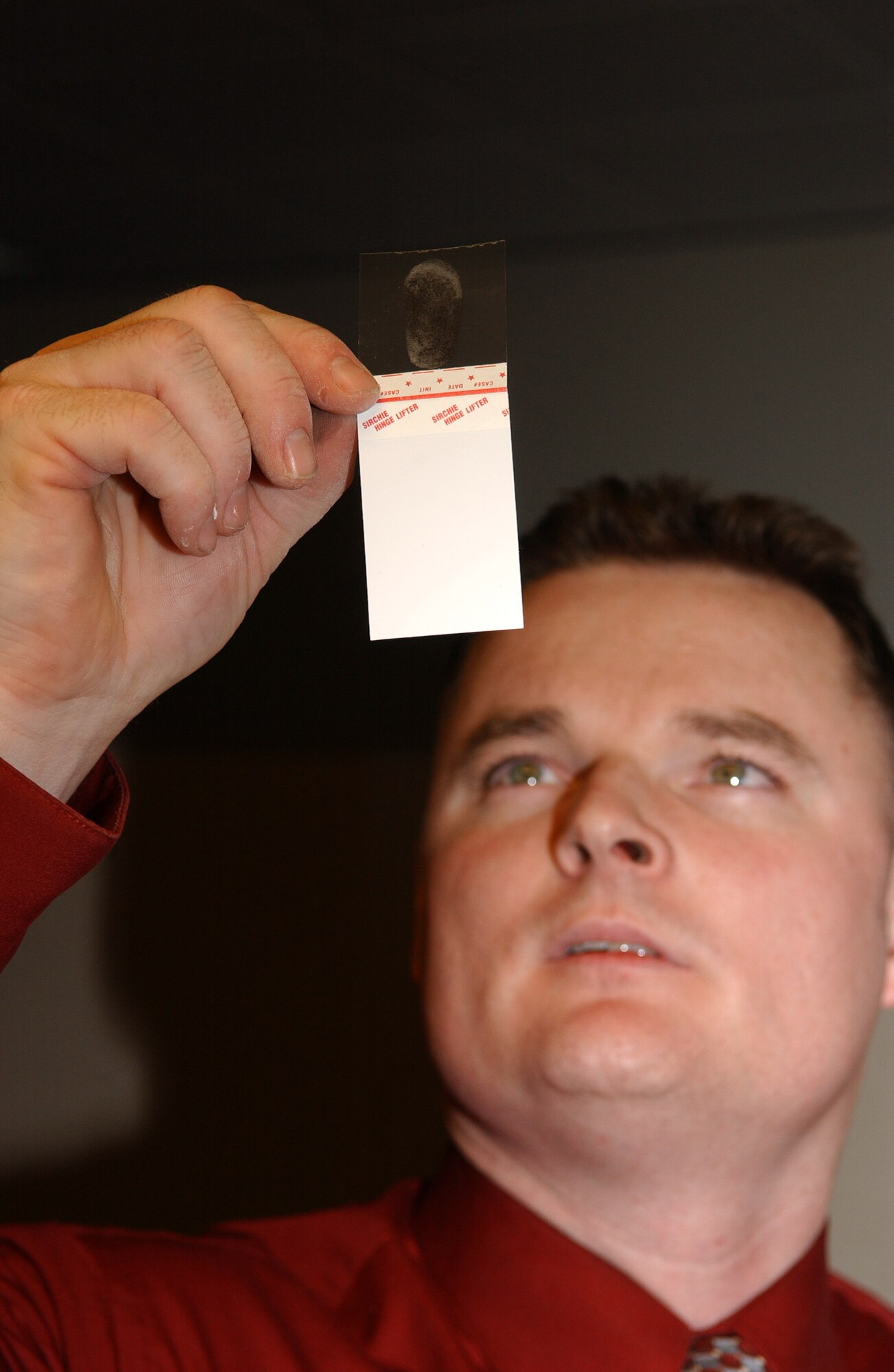 EIELSON AIR FORCE BASE, ALASKA--Investigator Christopher Stone, 354th Security Forces Squadron NCO in charge of investigations, evaluates a fingerprint lifted from a piece of evidence Feb. 2 at the 354th SFS complex. (U.S. Air Force photo by Senior Airman Anthony Nelson)