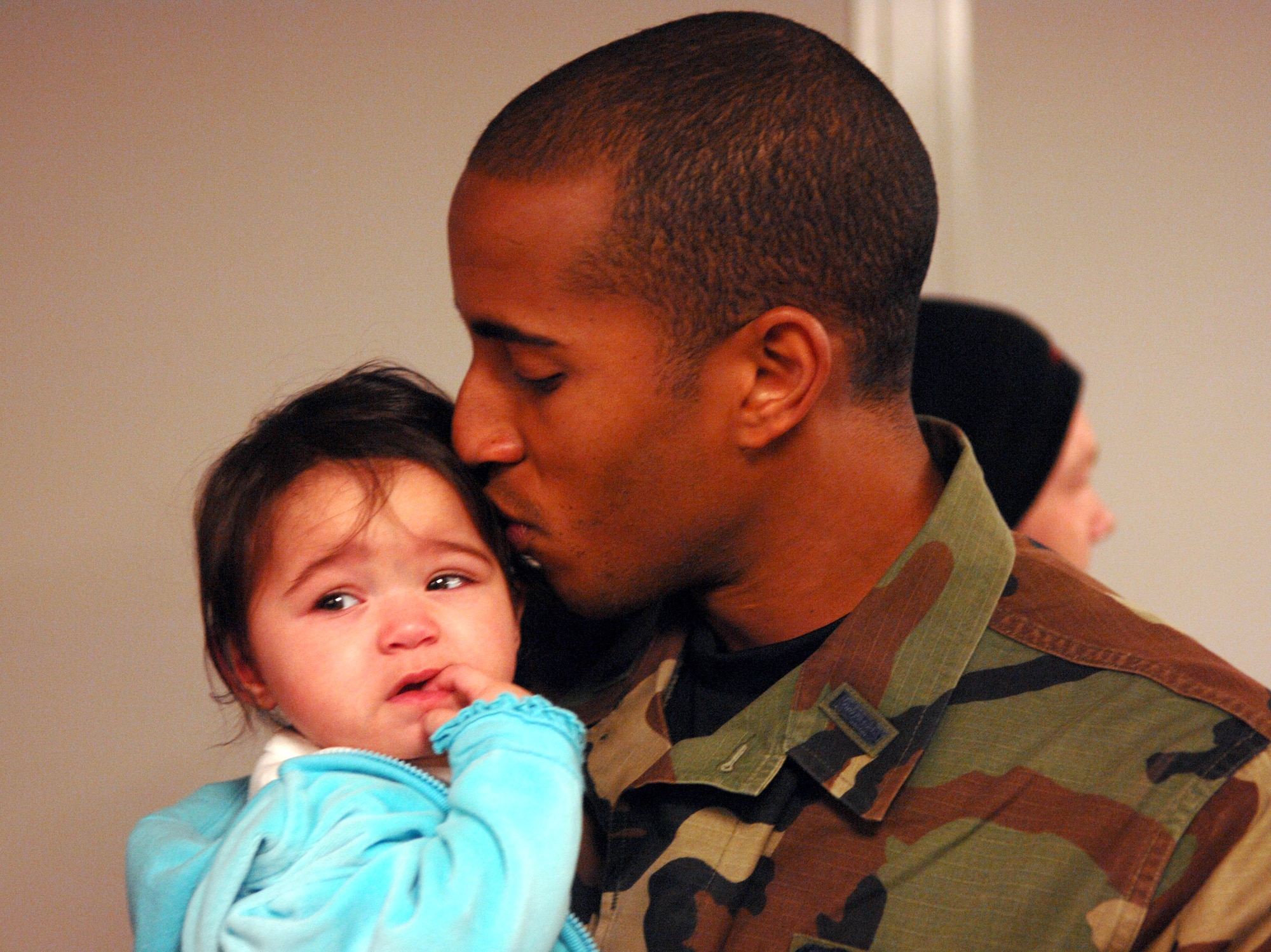1st Lt. Dwayne Clark kisses his daughter, Mikaila, after returning from a deployment Jan. 30 to Minot Air Force Base, N.D. Lieutenant Clark and 109 other Minot AFB Airmen were met by friends and family upon arriving home from a five–month deployment to Andersen AFB, Guam.  He is assigned to the 23rd Bomb Squadron.  (U.S. Air Force photo/Airman 1st Class Christopher Boitz)