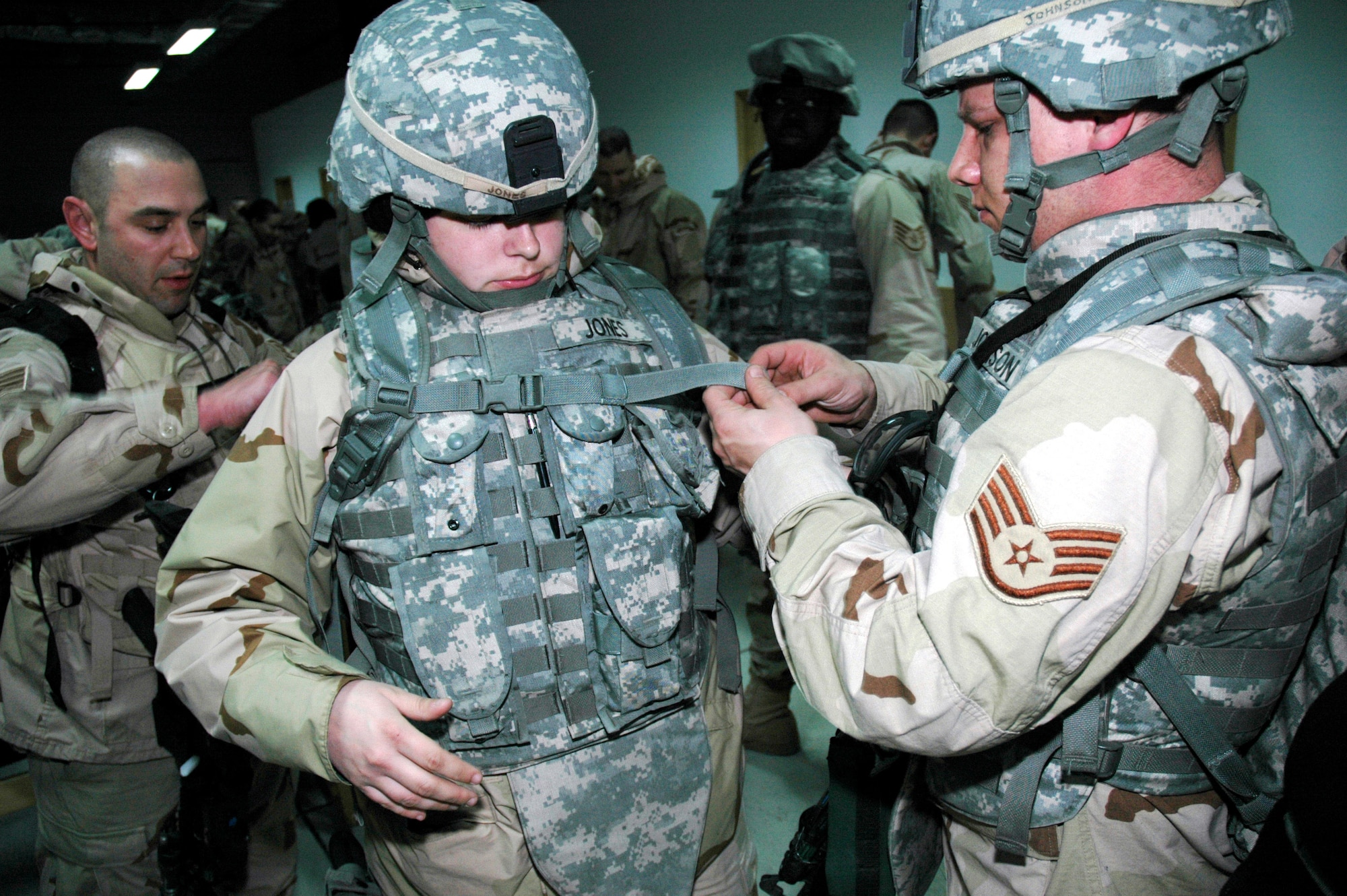 Staff Sgt. Jason Lapeyrouse (left) and Staff Sgt. James Johnson (right) help Senior Airman Emily Jones secure her flak vest Feb. 5 in prepartion for departure from Manas Air Base, Kyrgyzstan, to Afghanistan. Sergeant Lapeyrouse and Airman Jones are deployed from the 6th Medical Operations Squadron at MacDill Air Force Base, Fla. Sergeant Johnson is deployed from the 116th Air Control Wing at Robins AFB, Ga. The three are part of 170 Airmen who trained with the Army at Fort Riley, Kan., and will be deployed side by side with Soldiers in Afghanistan. (U.S. Air Force photo/Master Sgt. Daniel Nathaniel)