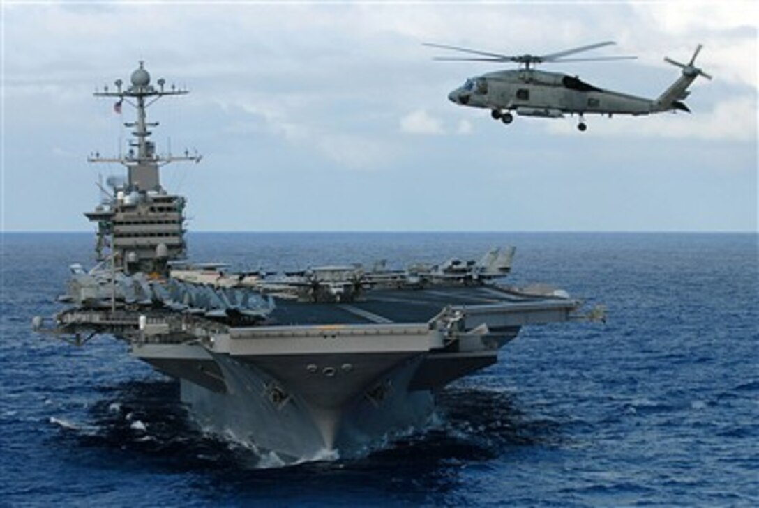 An SH-60F Sea Hawk helicopter from the Eightballers of Helicopter Anti-Submarine Squadron 8 hovers in front of USS John C. Stennis during a photo exercise showcasing the John C. Stennis Carrier Strike Group, off the coast of Guam, Feb. 6, 2007.