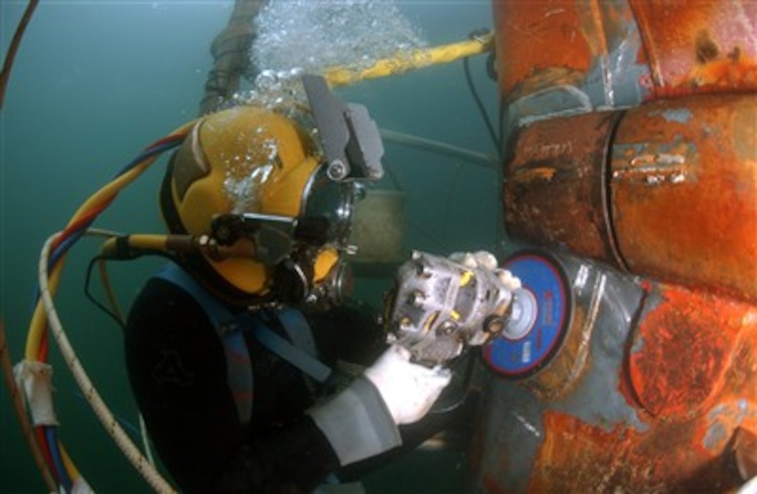 U.S. Navy Diver Petty Officer 1st Class Josh Moore uses a grinder to file down a repair patch on the submerged bow of the USS Ogden (LPD 5) while the ship is in port at Naval Base San Diego, Calif., on Jan. 4, 2007.  Moore is a member of the South West Region Maintenance Center Dive Locker's underwater welding team.  