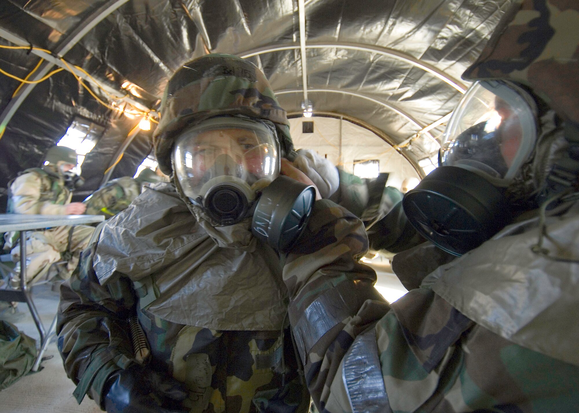 Airmen perform buddy checks on their chemical suits during the ORE. (Photo by Mike Cassidy)