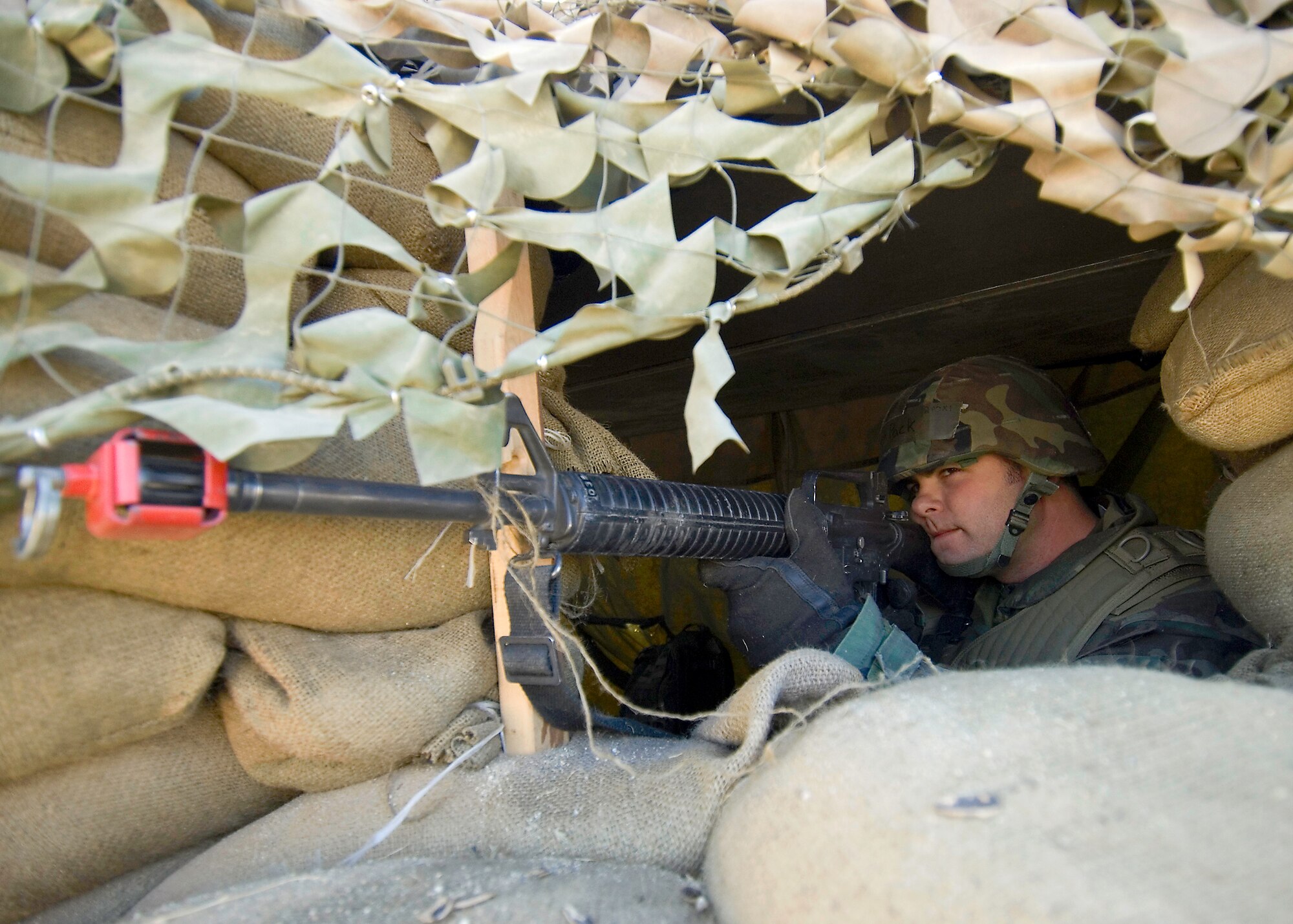 A security forces augmentee aims from a bunker during an attack. (Photo by Mike Cassidy)
