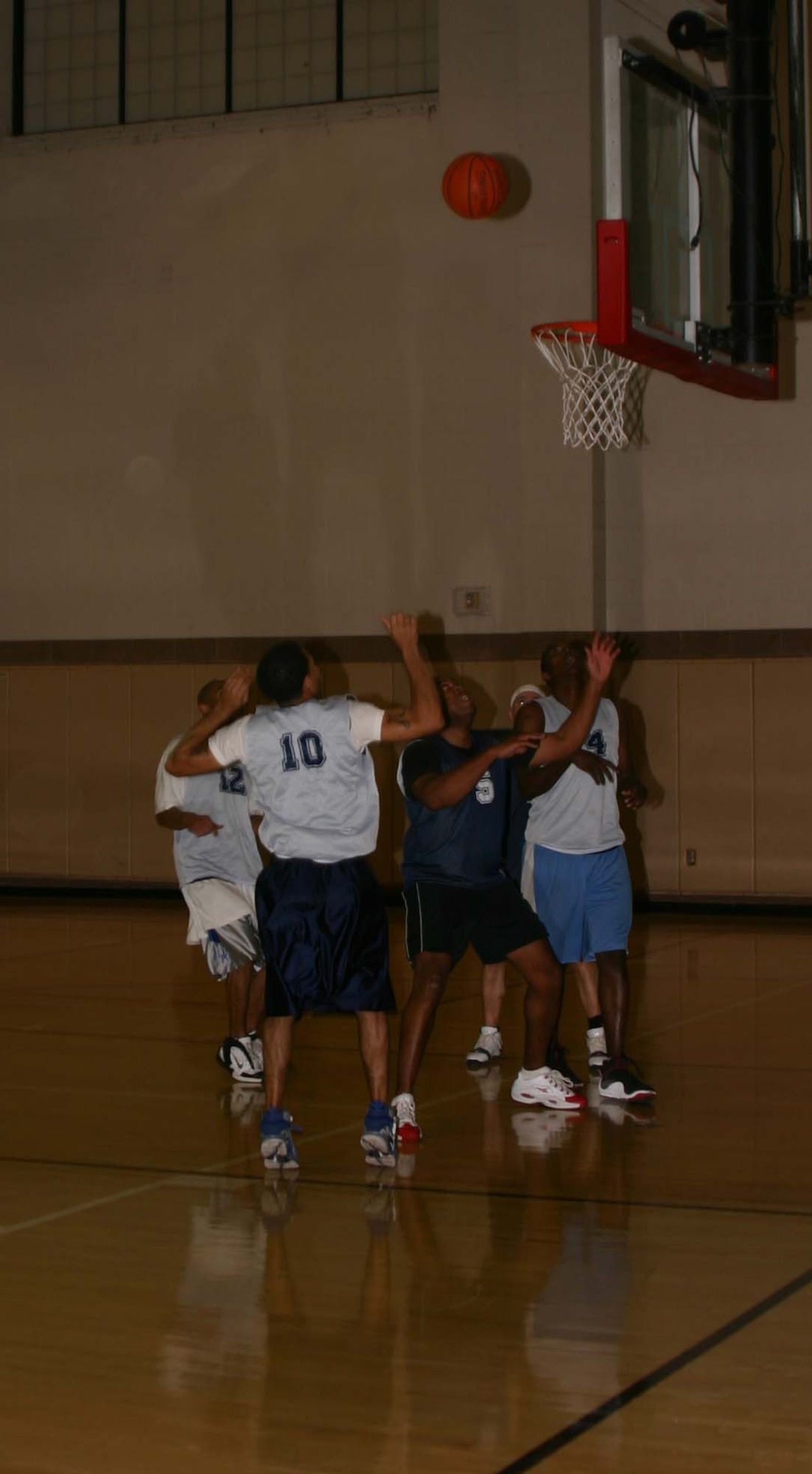 Players for the 264th Medical Battalion and the 365th Training Squadron surround the basket during the Feb. 7 game.  The 264th won the game, 77-73.