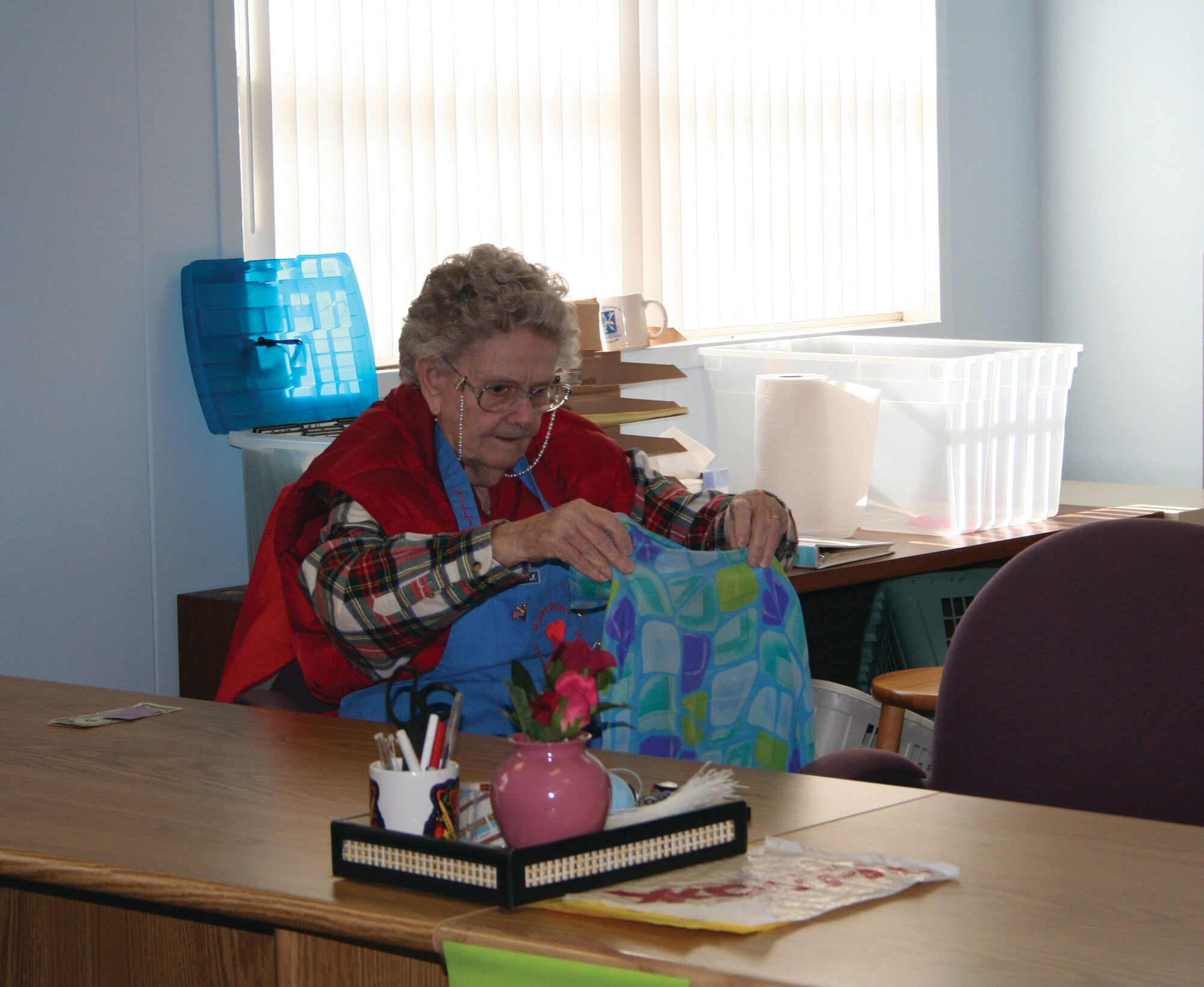Lillian Hollestelle checks a garment that was brought into the Hurlburt Spouse's Club thrift shop, before putting it on display. Ms. Hollestelle has volunteered at the thrift shop for more than 20 years. (Courtesy Photograph)