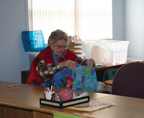 Lillian Hollestelle checks a garment that was brought into the Hurlburt Spouse's Club thrift shop, before putting it on display. Ms. Hollestelle has volunteered at the thrift shop for more than 20 years. (Courtesy Photograph)