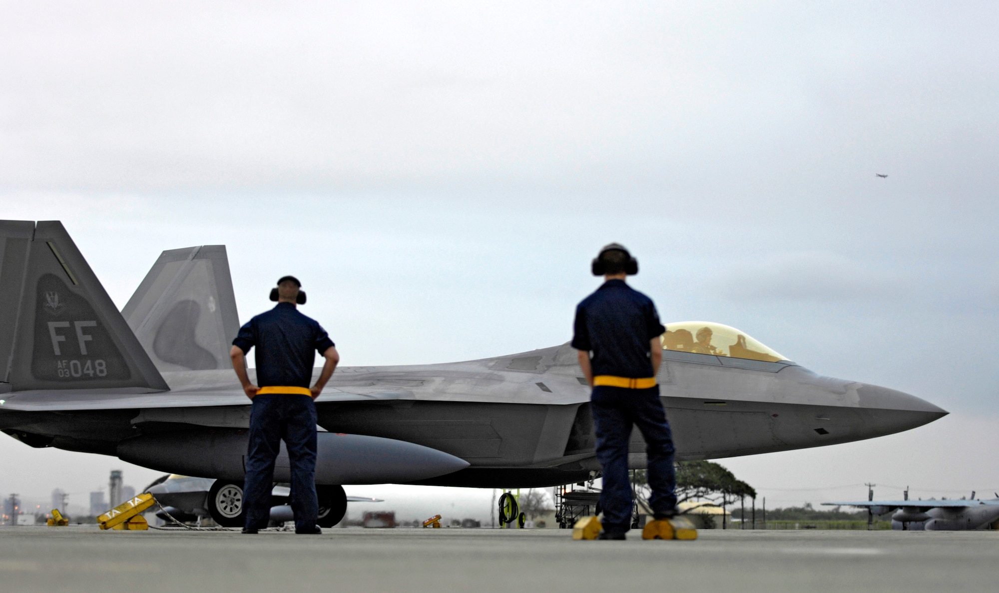 Two crew chiefs watch as an F-22 Raptor taxis to its parking spot Feb. 7 at Hickam Air Force Base, Hawaii. The F-22s and more than 250 Airmen from the 27th Fighter Squadron at Langley Air Force Base, Va., are bound for Kadena Air Base, Japan, for the aircraft's first overseas operational deployment. (U.S. Air Force photo/Tech. Sgt. Shane A. Cuomo) 
