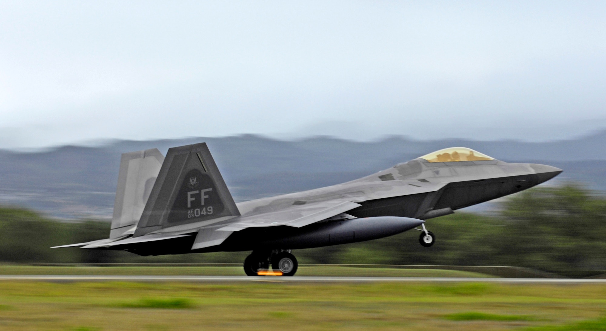 The first of 12 F-22 Raptors lands for a brief layover Feb. 7 at Hickam Air Force Base, Hawaii. The F-22s and more than 250 Airmen from the 27th Fighter Squadron at Langley Air Force Base, Va., are bound for Kadena Air Base, Japan, for the aircaft's first overseas operational deployment. (U.S. Air Force photo/Tech. Sgt. Shane A. Cuomo) 