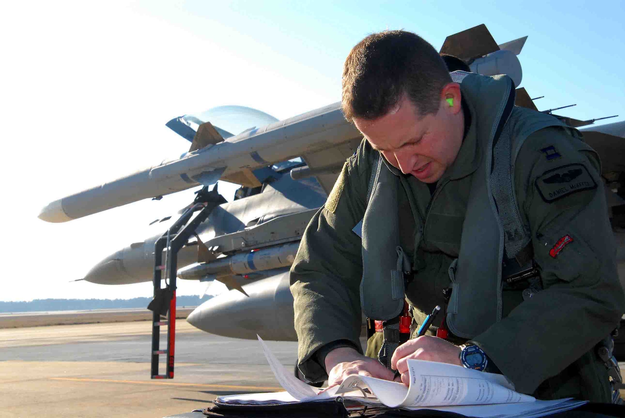 SHAW AIR FORCE BASE, S.C. -- Capt. Daniel McAffee, 77th Fighter Squadron, makes a note in the flight log before piloting an F-16CJ during the Operation Iron Thunder exercise Feb. 7. The four-day exercise prepares pilots for future contingency operations by exposing them to missions identical to those faced in combat. (U.S. Air Force Photo/Tech. Sgt. James Arrowood)