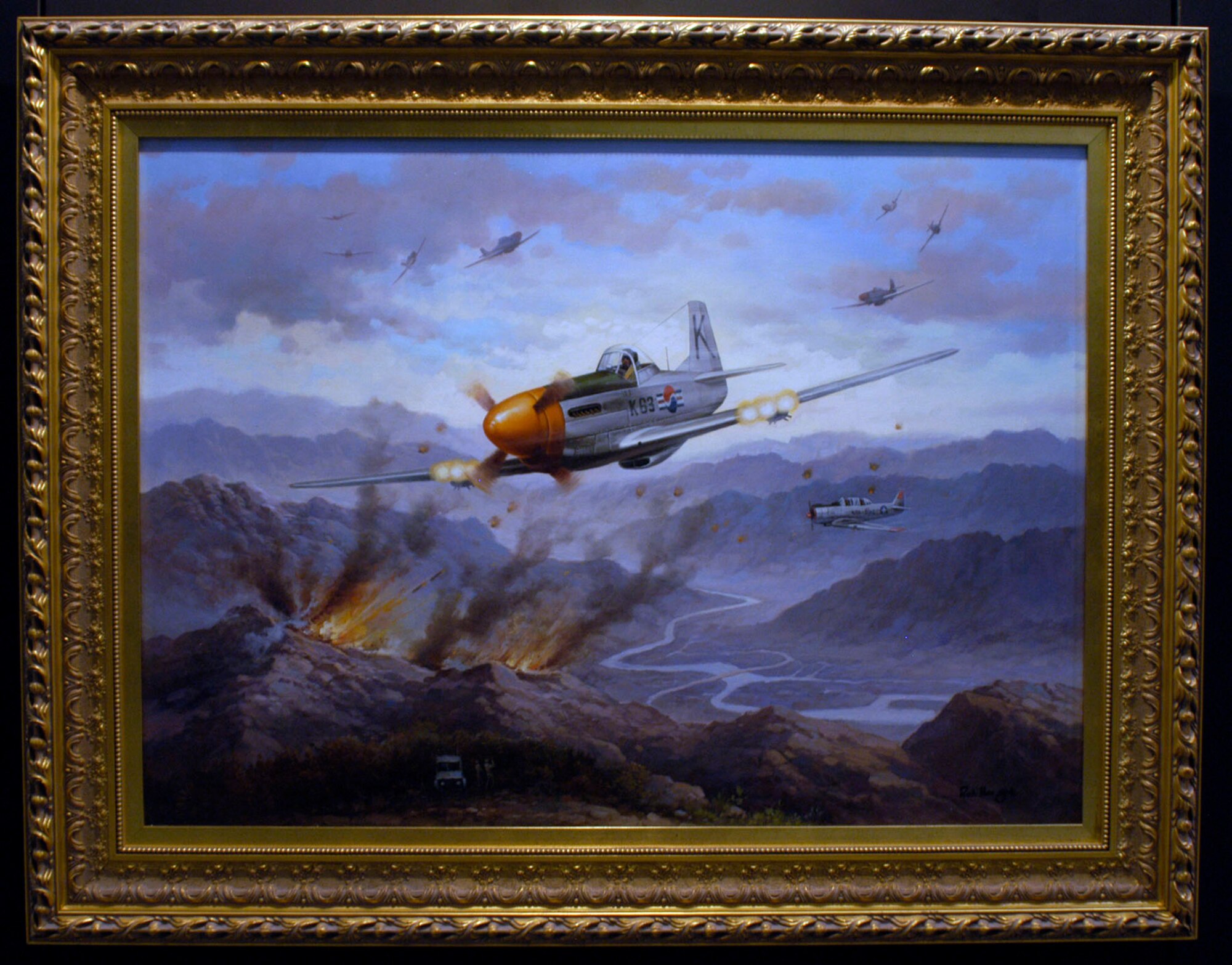 DAYTON, Ohio - Painting by Roh Hee Gak on display in the Korean War Gallery at the National Museum of the U.S. Air Force. On March 26, 1952, 16 F-51 Mustang fighter-bombers of the newly-created Republic of Korea Air Force (ROKAF) led by Maj. E. Yul Yoon furiously attacked communist ground forces attacking Hill 351. The air-to-ground action was being directed by a USAF T-6 Mosquito airborne forward air controller flown by Maj. William Light and ROKAF Capt. Sang K. Wie along with a USAF ground-based control party. During this action, U.S. Navy aircraft and ROK Army artillery successfully suppressed enemy anti-aircraft fire. This joint action enabled the ROK 15th Infantry Division to effectively hold the strategic heights of Hill 351.This multi-national action illustrates the rapid growth and combat effectiveness of ROK military forces, both air and ground, and their ability to conduct joint operations with U.S. military forces. (U.S. Air Force photo)