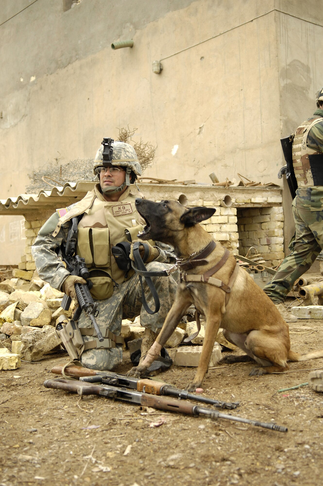 Tech. Sgt. Harvey Holt and his military working dog take a short break Feb. 6 during a patrol in Kahn Bani Sahd, Iraq, with U.S. and Iraqi soldiers.  Airmen continue to excel in nontraditional combat roles in support of combatant commanders' requirements where Airmen are deployed to assist Soldiers.  Sergeant Holt is assigned to the 732nd Expeditionary Security Forces Squadron.  (U.S. Air Force photo/Staff Sgt. Stacy L. Pearsall)