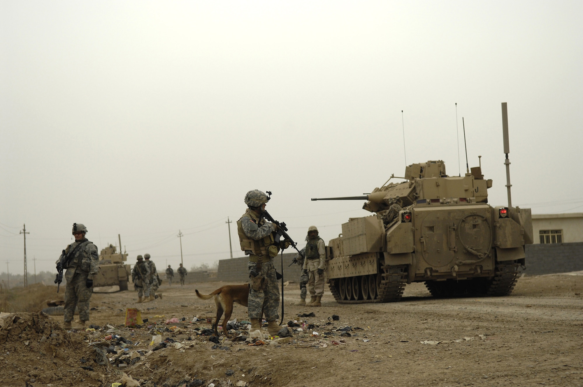 Tech. Sgt. Harvey Holt and his military working dog accompany Soldiers from the 1st Cavalry Division Feb. 6 during a patrol in Kahn Bani Sahd, Iraq.  Airmen continue to excel in nontraditional combat roles in support of combatant commanders' requirements where Airmen are deployed to assist Soldiers.  Sergeant Holt is assigned to the 732nd Expeditionary Security Forces Squadron.  (U.S. Air Force photo/Staff Sgt. Stacy L. Pearsall) 