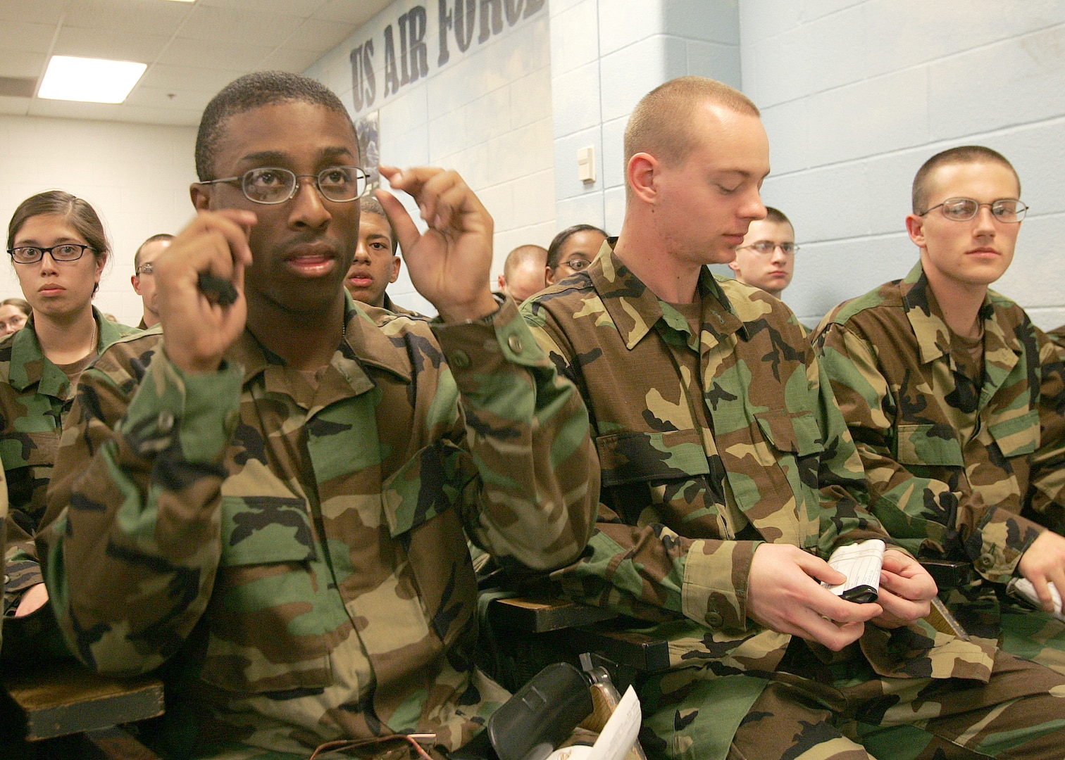 Trainee Cameron Cruz adjusts his black-rimmed frame-of-choice glasses, while Trainee Logan Schneider prepares to open the case of his newly received glasses Feb. 5, 2007, at the 331st Training Squadron. At right is Trainee Michael Falgout, also in Flight 189, 331st TRS, already wearing his black-rimmed FOC glasses. The frames-of-choice for trainees was an initiative of Brig. Gen. Darrell Jones, a former 37th Training Wing commander at Lackland Air Force Base, Texas. (USAF photo by Robbin Cresswell)