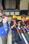 During the pinewood derby Jan. 29, Riley Naylor (left) watches his car slide down the track, Luke Eubanks appears to be willing his car to win and David Zully holds up his hand in anticipation. Cub Scout Pack 651 conducted their derby at the Lackland Elementary School at Lackland Air Force Base, Texas. Riely's car was one of the three overall fastest cars in the derby. He was also one of the top two fastest cars from his Wolf den. (Photo by Army Spc. Tim Luukkonen)