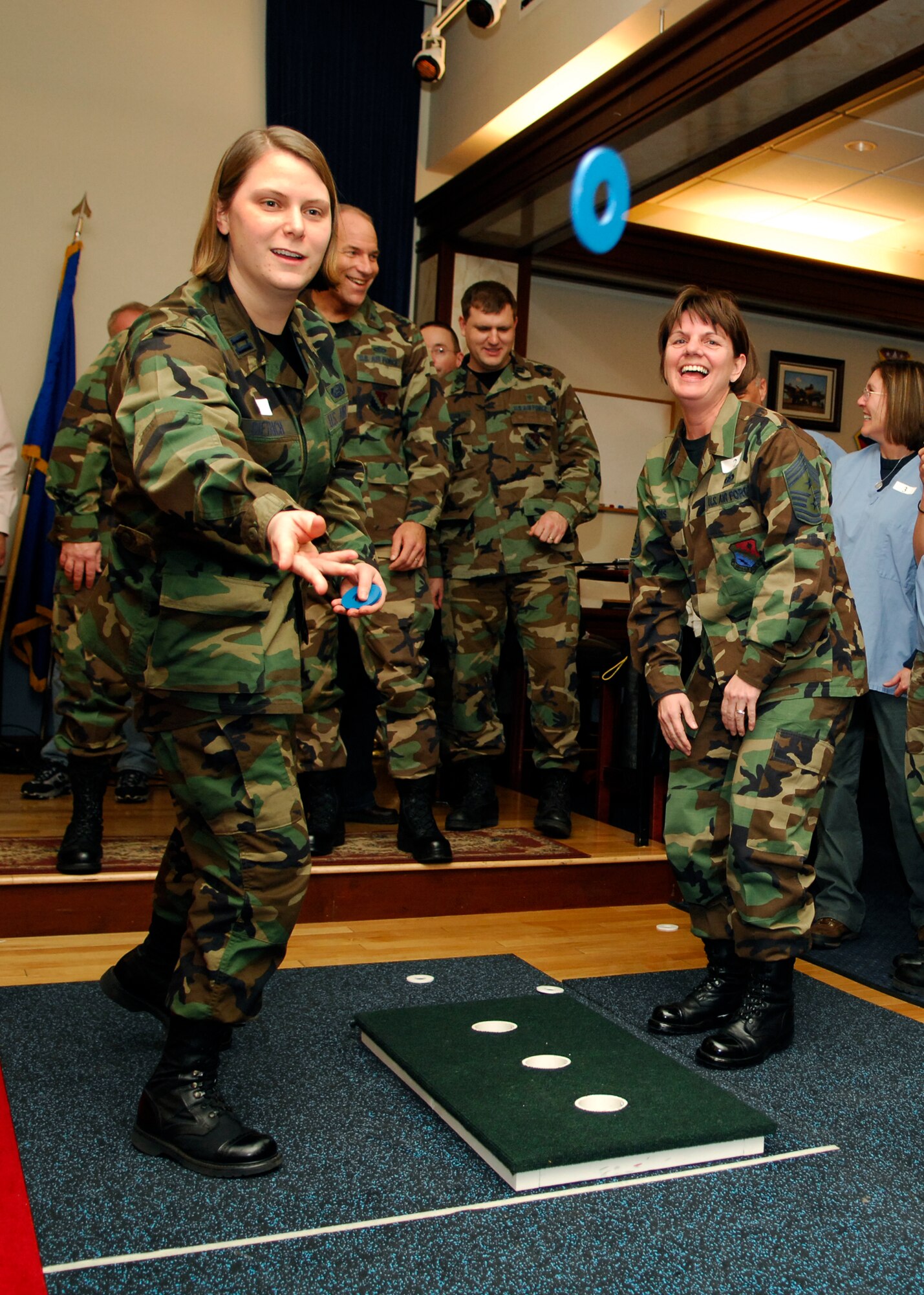 Capt. Mandye Dietrich, 66th Air Base Wing executive officer, tosses a washer during the base's first Washers Tournament, which was held at the Minuteman Club Feb. 2. Washers is an indoor and outdoor game that is played and scored similarly to horseshoes. (US Air Force Photo by Mark Wyatt)