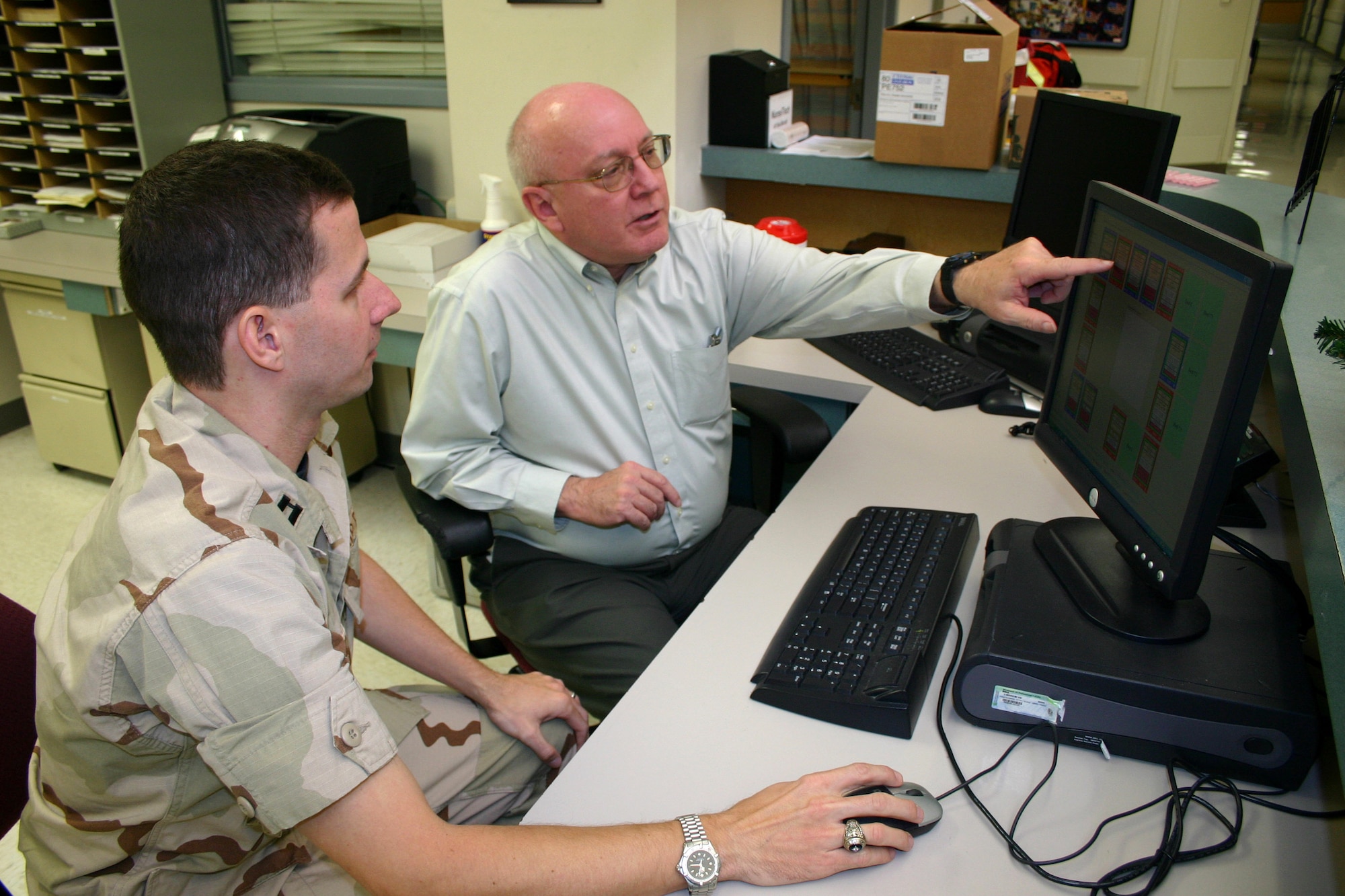 Capt. (Dr.) Allen Holder discusses graphical interface elements for a patient tracking system designed at Wilford Hall Medical Center with software engineer Ed Hander at Lackland Air Force Base, Texas. Now-Major Holder and Mr. Hander were key to the 59th Medical Wing being recognized during the annual TRICARE conference as a 2006 Department of Defense Patient Safety Award winner. (U.S. Air Force photo/Master Sgt. Kimberly Spencer)

