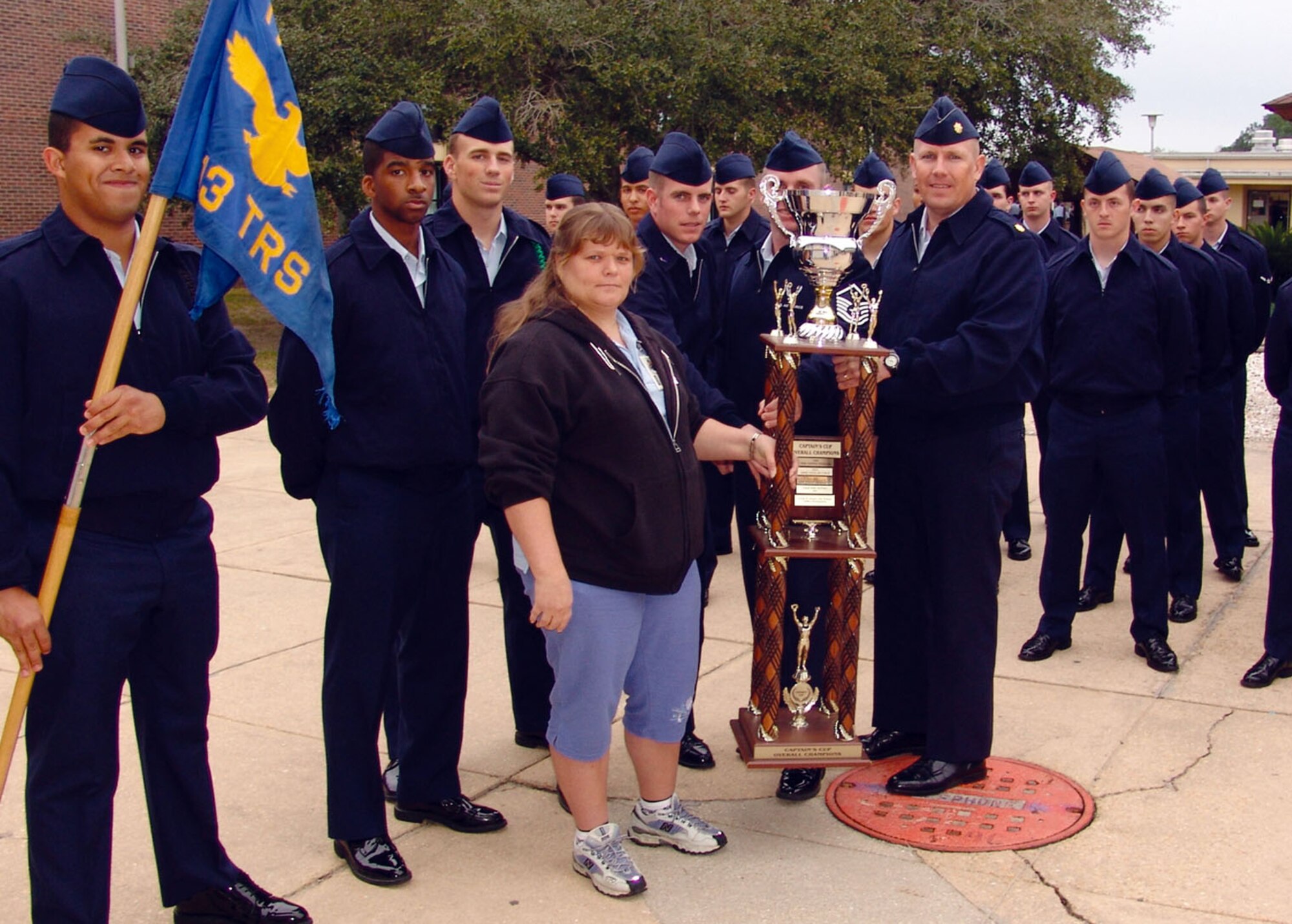Maj. Hal Brown holds up the Captain’s Cup as he and members of the 313th Training Squadron pose for a group photo. The U.S. Air Force 313 TRS at the Center for Information Dominance won the 2006 Corry Station Captain’s Cup Jan. 19 for the fourth time in size years. (U.S. Air Force photo by Darlene Goodwin)