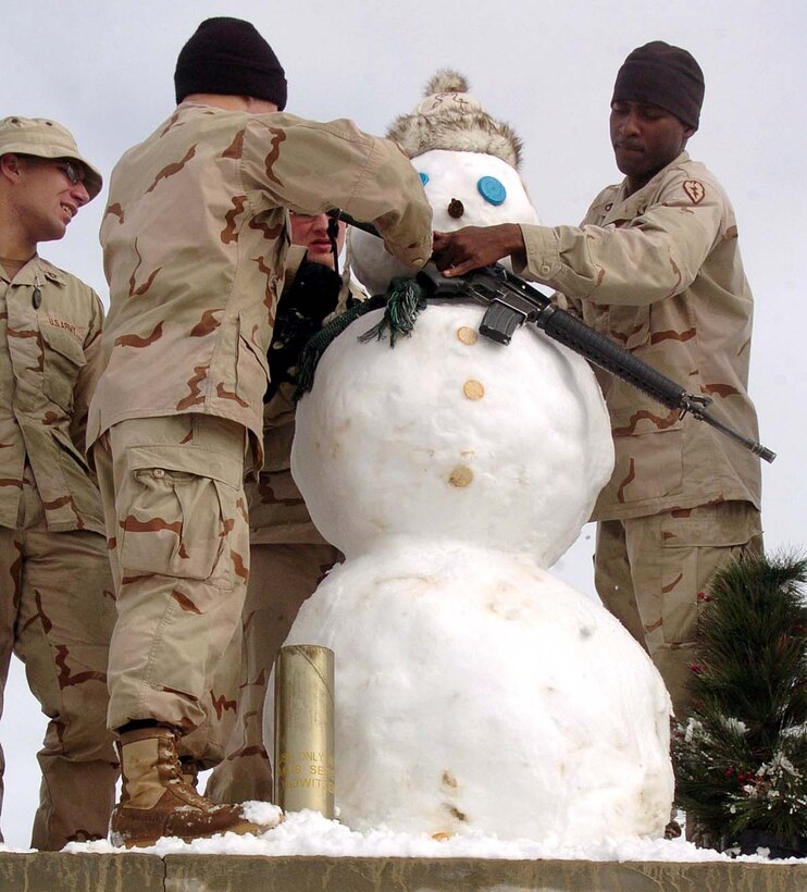 Soldiers from Battery B, 3rd Battalion, 7th Field Artillery 
Regiment, put the finishing touches on a snowman Dec. 29 at Forward Operating 
Base Orgun-E, Afghanistan, after a foot of snow fell on the base over the 
previous 36 hours. Photo by Staff Sgt. Bradley Rhen, USA