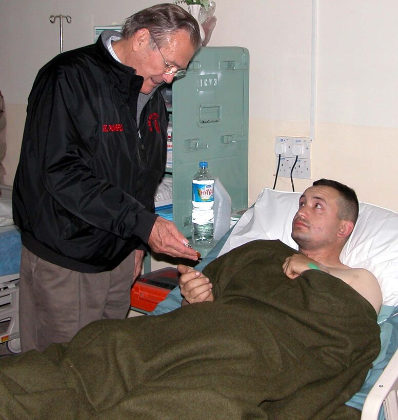 Defense Secretary Donald H. Rumsfeld presents the Purple 
Heart Medal to Army Sgt. Chris Scott, 29, of Oklahoma City, Okla., Dec. 24 at 
the 67th Combat Surgical Hospital in Mosul, Iraq. Rumsfeld shared Christmas-Eve 
cheer with U.S. troops serving in Baghdad and in the cities of Mosul, Tikrit 
and Fallujah. Photo by Gerry J. Gilmore