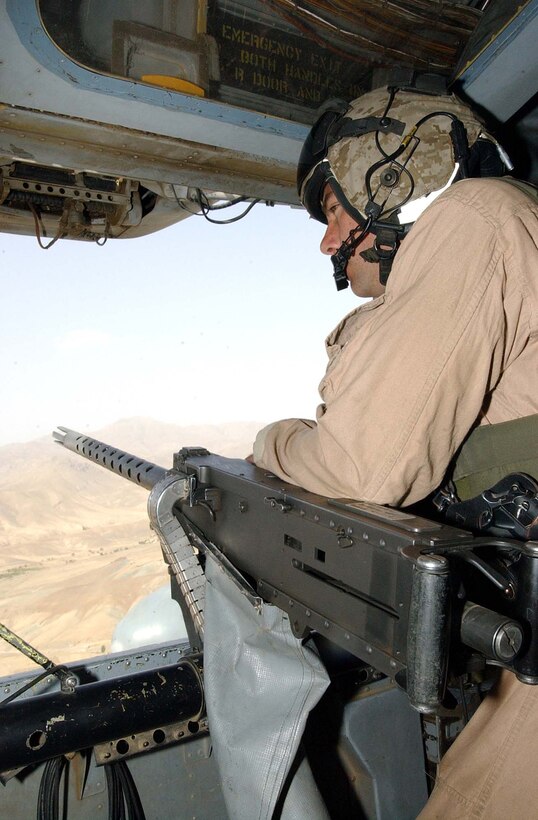 Marine Gunnery Sgt. John Ellis, a crew chief with Heavy 
Marine Helicopter Squadron 769, scans the ground below for potential threats to 
his CH-53 Sea Stallion during a flight to Forward Operating Base Asadabad, 
Afghanistan. The Marines of HMH-769 regularly transferred troops and equipment 
throughout Afghanistan during their seven-month deployment. Photo by Staff Sgt. 
Monica Garreau, USA