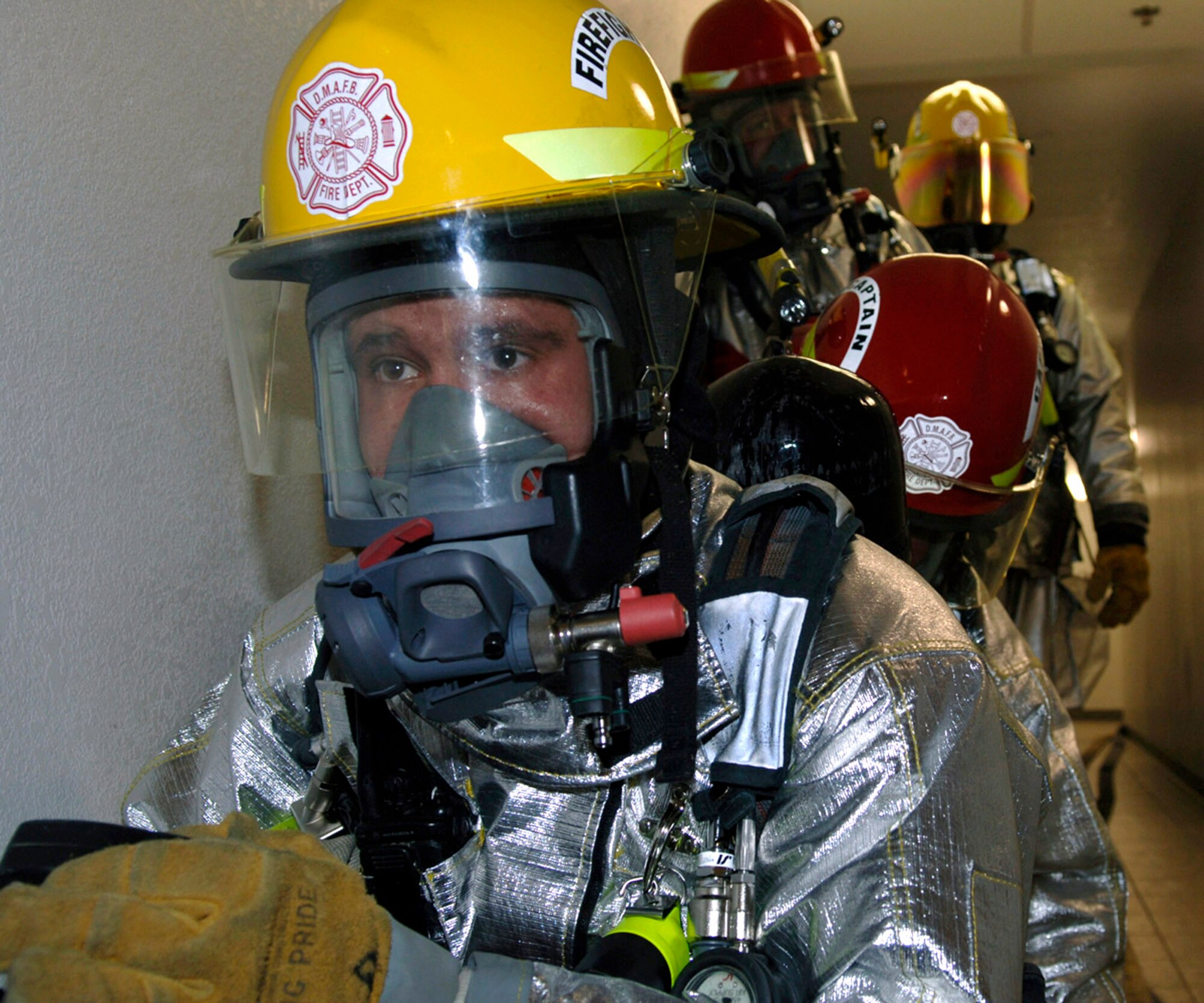 Senior Airman Michael Lewis, Airman 1st Class Robert Whitaker and Tech. Sgt. Steven Nordlund prepare to search for personnel left inside a building during a simulated fire and evacuation at Davis-Monthan Air Force Base, Ariz., in preparation for an operational readiness inspection. The three Airmen are firefighters assigned to the 355th Civil Engineer Squadron. (U.S. Air Force photo/Senior Airman Christina D. Ponte)
