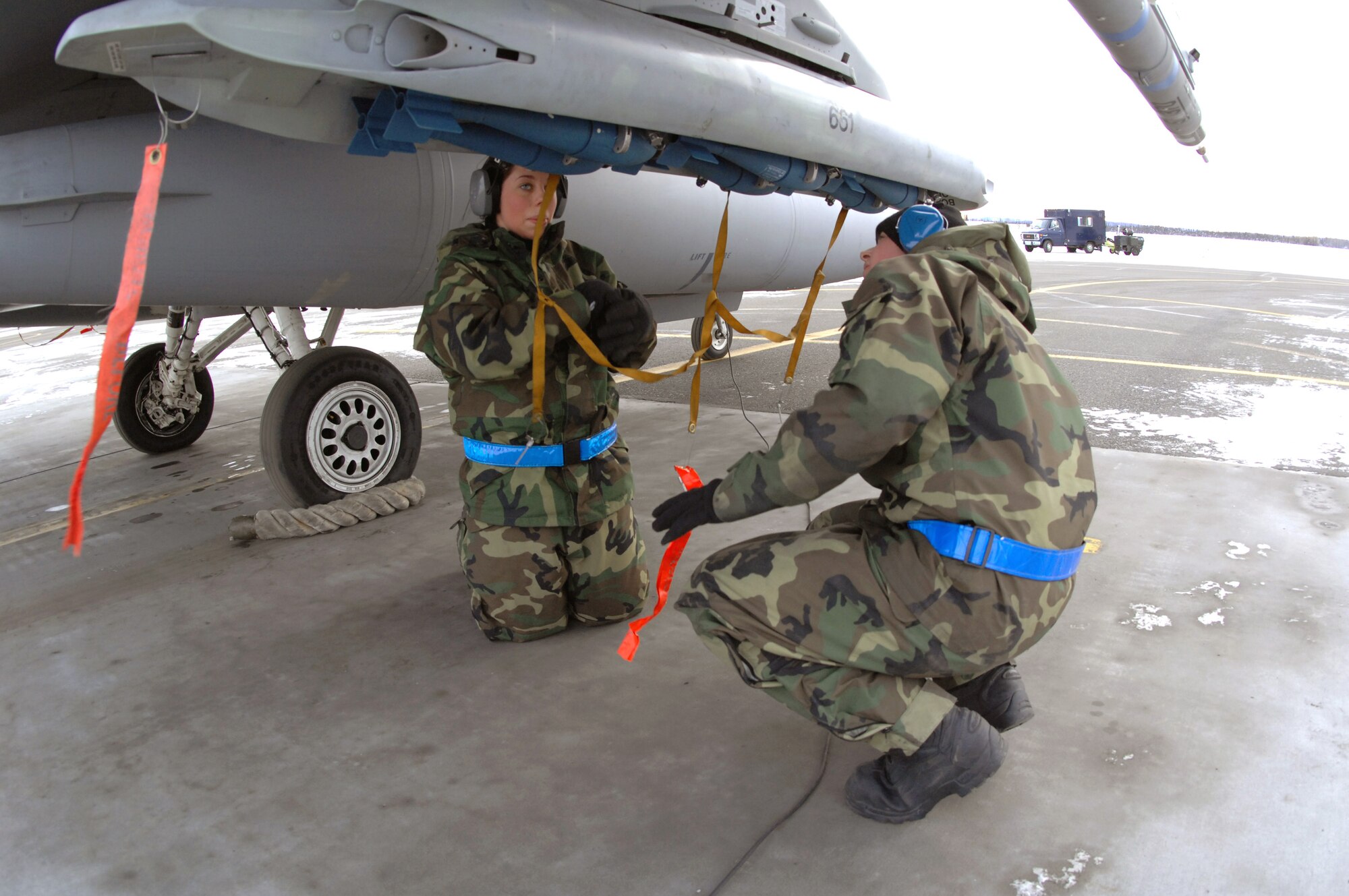 Senior Airman Amanda Debkowski and Airman 1st Class Justin Hendrick prep an F-16 Fighting Falcon Feb. 8 at Eielson Air Force Base, Alaska. The 354th Maintenance Squadron Airmen are responsible for arming all weapons and making sure aircraft are ready for flight. The 18th Fighter Squadron conducts air operations for combat-ready F-16 aircraft and provides close-air support, forward air control, battlefield air interdiction, and offensive counter air. (U.S. Air Force photo/Staff Sgt. Joshua Strang) 
