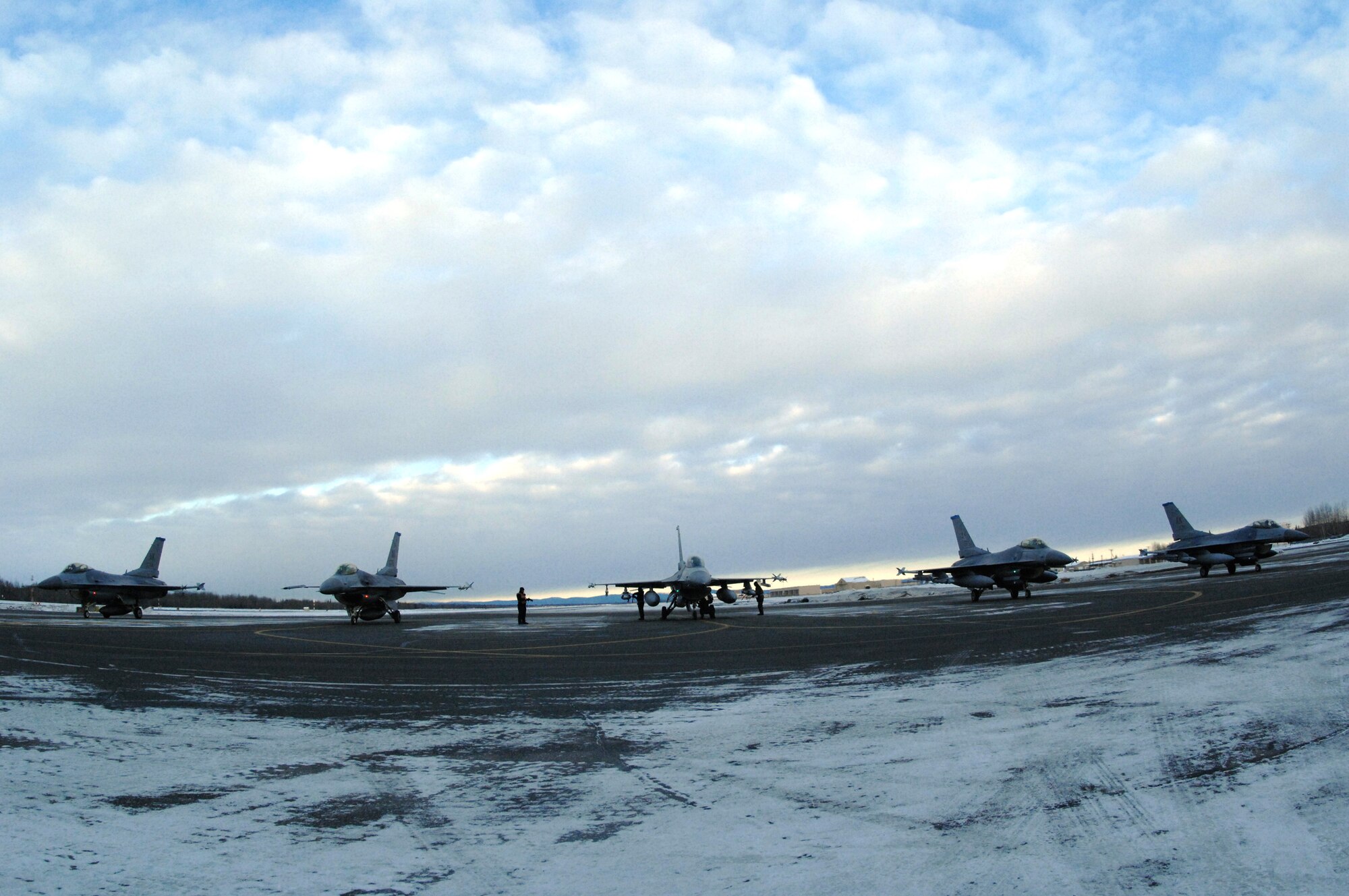 Airmen arm and inspect five F-16 Fighting Falcons Feb. 8 at Eielson Air Force Base, Alaska. The crew is responsible for arming all weapons and making sure aircraft are ready for flight. The 18th Fighter Squadron here conducts air operations for combat-ready F-16 aircraft and provides close-air support, forward air control, battlefield air interdiction, and offensive counter air. The crew is assigned to the 354th Maintenance Squadron. (U.S. Air Force photo/Staff Sgt Joshua Strang)
