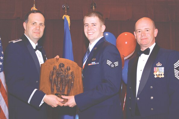 MCCHORD AIR FORCE BASE, Wash. -- Col. Jerry Martinez, 62nd Airlift Wing commander, left, and Chief Master Sgt. Russell Kuck, 62nd AW command chief master sergeant, right, present Airman of the Year Senior Airman Marc Spangler, 62nd Communications Squadron, with his award Feb. 1 at the 62nd AW Annual Awards Banquet at McChord?s Clubs and Community Center.(U.S. Air Force Photo/Master Sgt. Richard Hinckley)