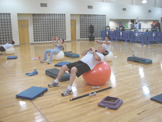 MCCHORD AIR FORCE BASE, Wash. -- Fitness readiness class participants do crunches on balance balls at the fitness center annex  Feb. 5.(U.S. Air Force Photo/Tyler Hemstreet)