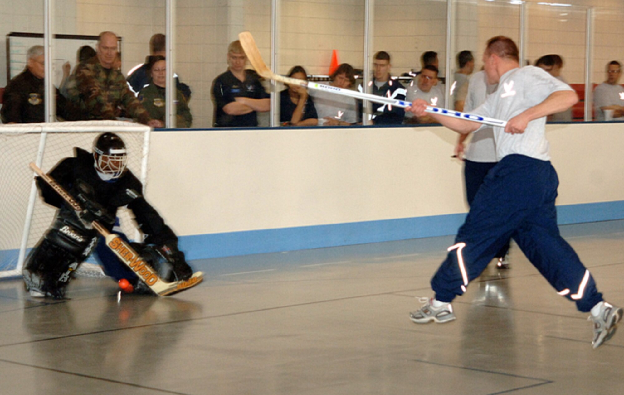 Maj. Gen. Quentin Peterson, director of operations of Air Mobility Command; Col. Raymond Corcoran, 319th Maintenance Group commander; and Col. Diane Hull, 319th Air Refueling Wing commander, watch from behind the goalie during a hockey game Feb. 8 during the Tanker Winter Symposium. Airmen competed in floor hockey, indoor rock climbing, track, dodge ball and human dog sled racing as team building sports. More than 60 Airmen attended the event. (U.S. Air Force photo/Airman 1st Class Chad Kellum)